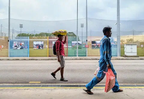 Migrant workers carrying groceries they bought at the minimart in Cochrane Recreation Centre in Sembawang on Feb 16.