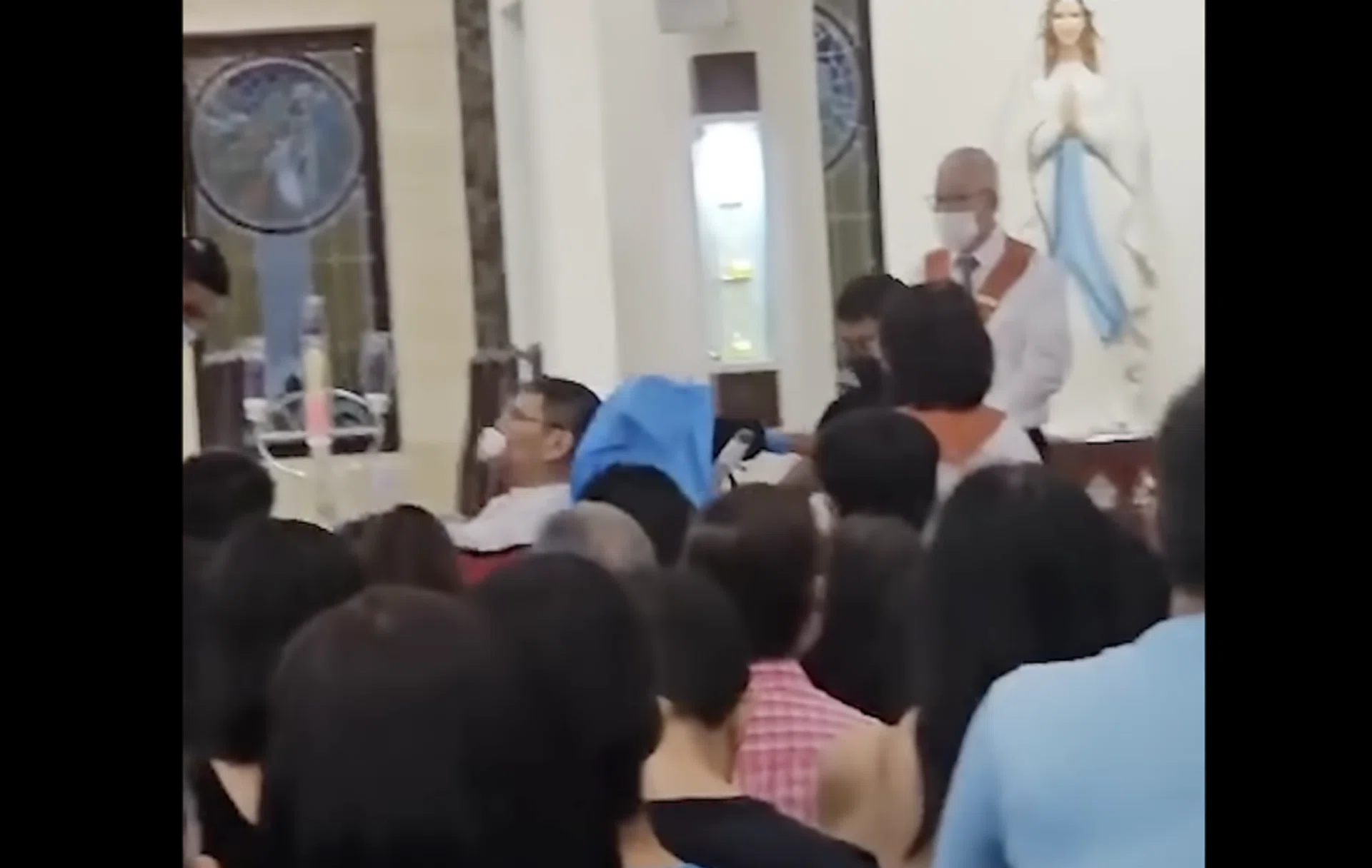 Screengrab of a video clip circulating online, showing Father Christopher Lee being taken away.
