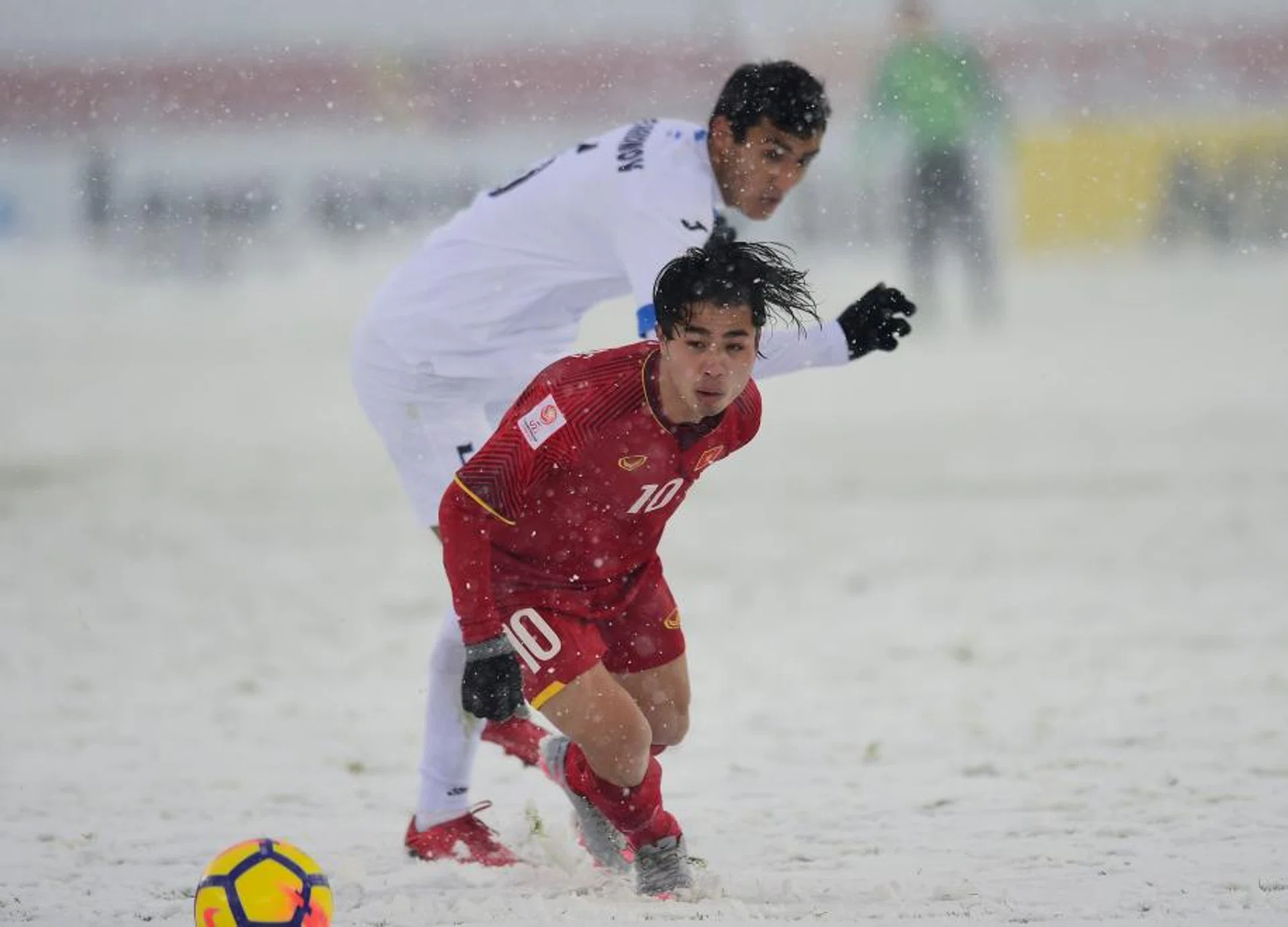 Uzbekistan's Otakhonov Abbosjon (in white) competes for the ball with Vietnam's Nguyen Cong Phuong.