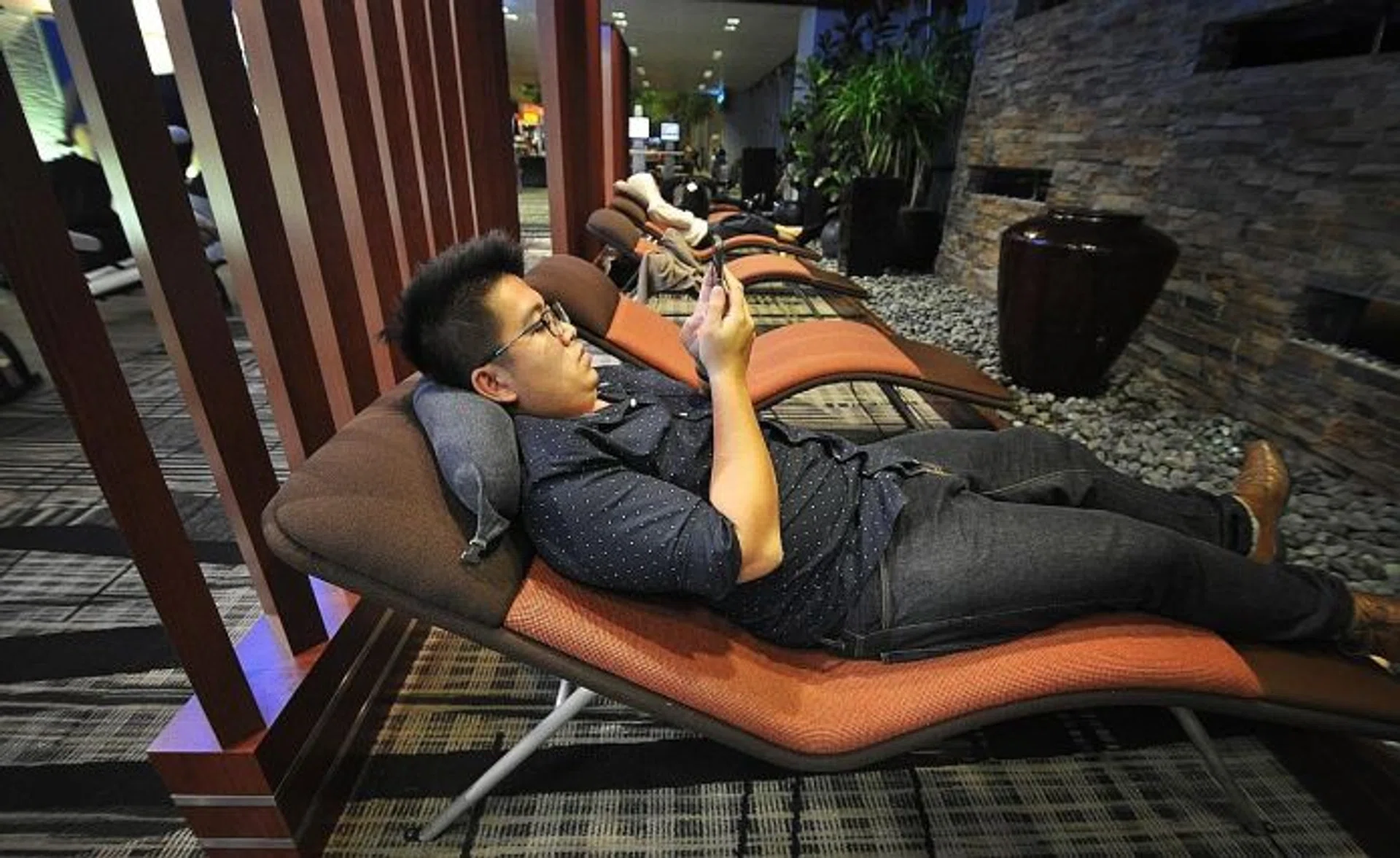 TNP reporter Ng Jun Sen tries to relax in Changi Airport's transit area.