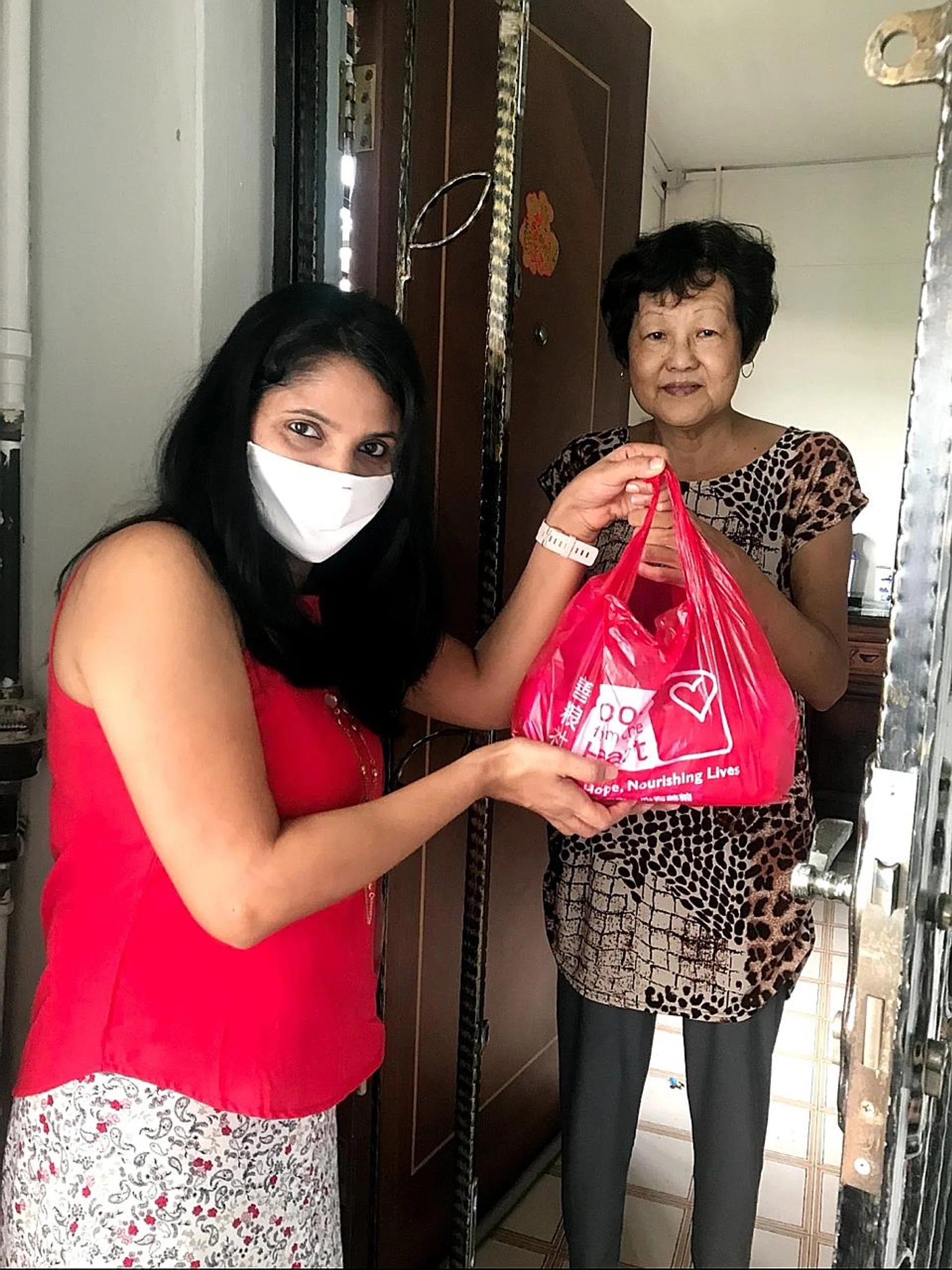  (Above) Food From The Heart volunteers delivering monthly care packs to beneficiaries.  