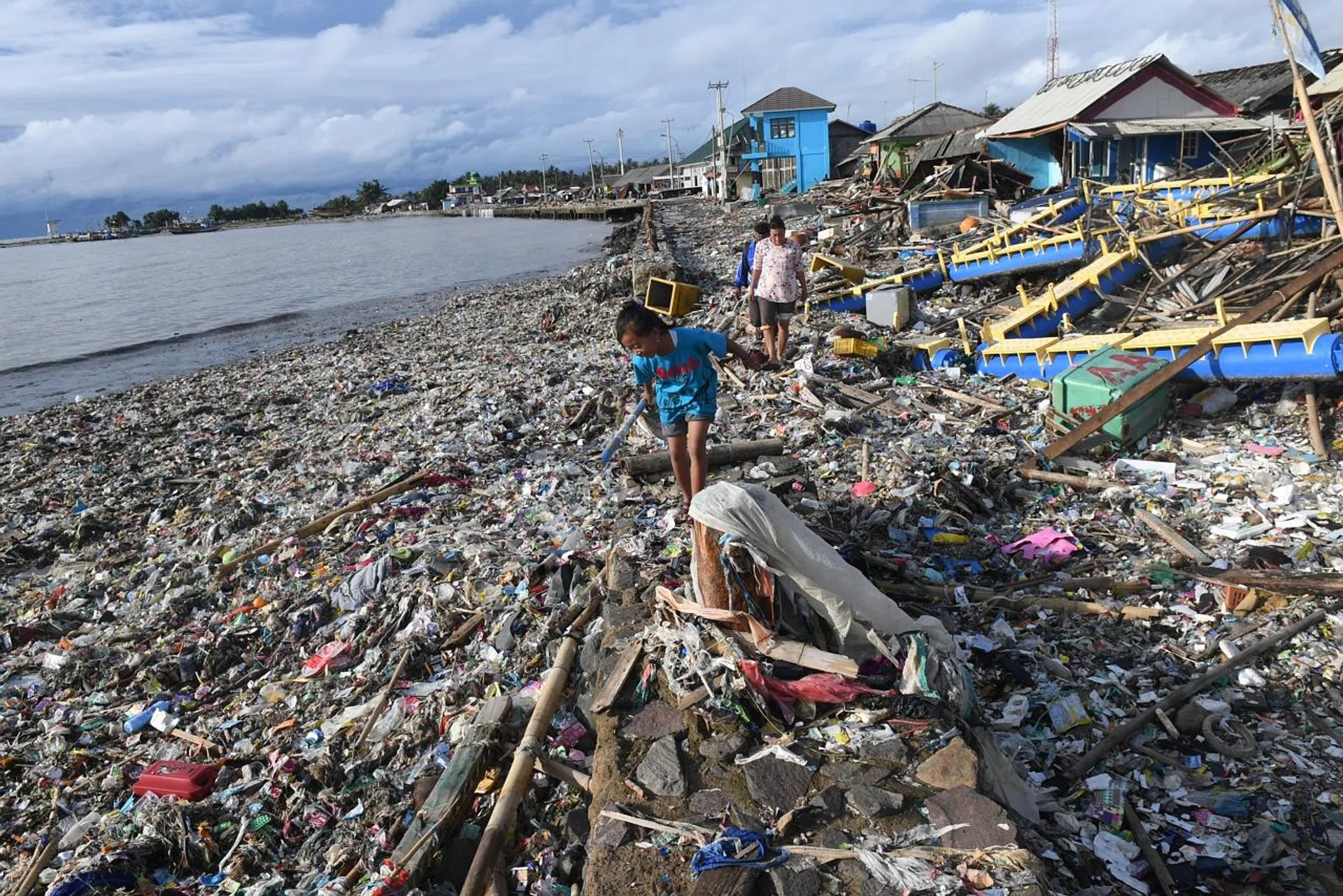 Residents walking among debris after the tsunami at Labuan in Banten province.
