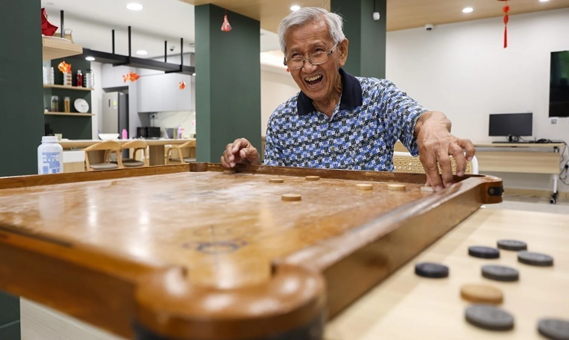 Mr Lam Shaw Ying, 88, a retired school supplier, playing carrom at the Good Old Place in Harmony Village @ Bukit Batok on Jan 7. 