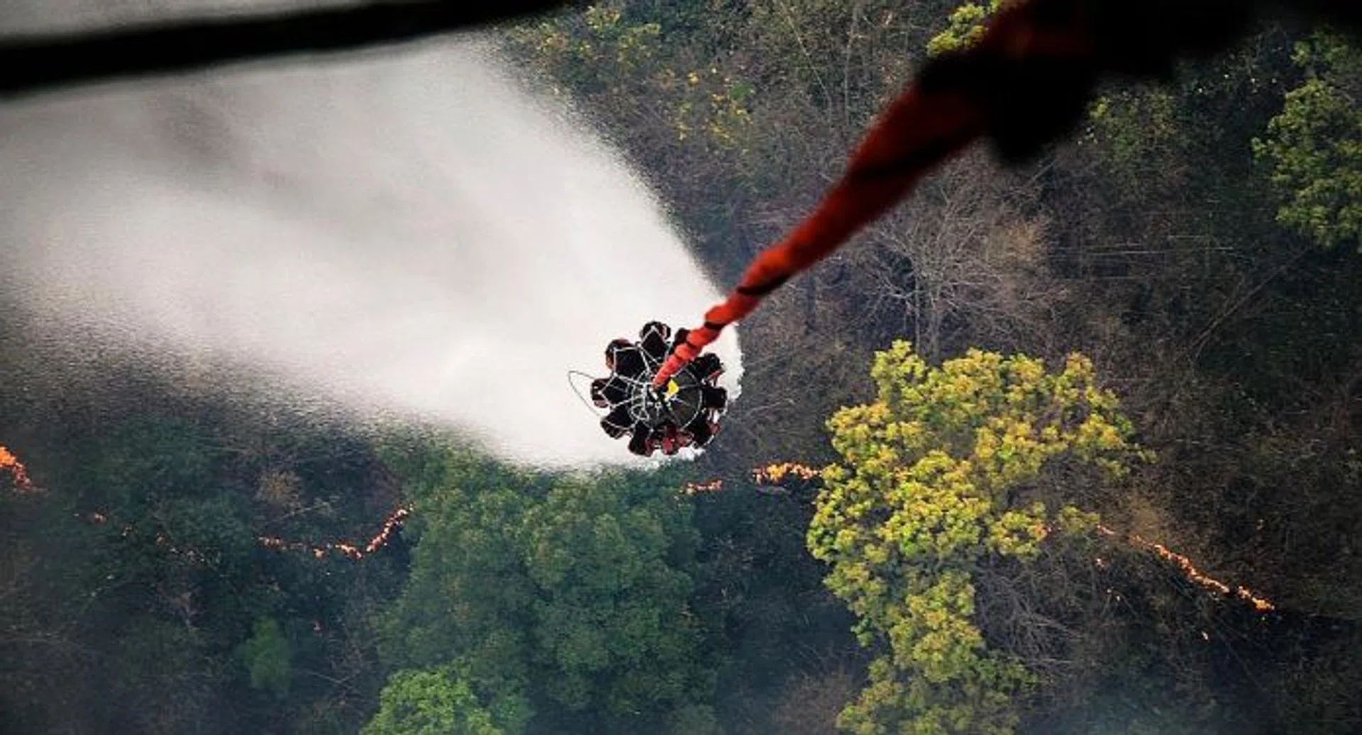 WATERWORKS: The Chinook is flown to a water source and a heli-bucket - which can hold up to 5,000 litres of water - is lowered to collect water for dousing flames at a hotspot.