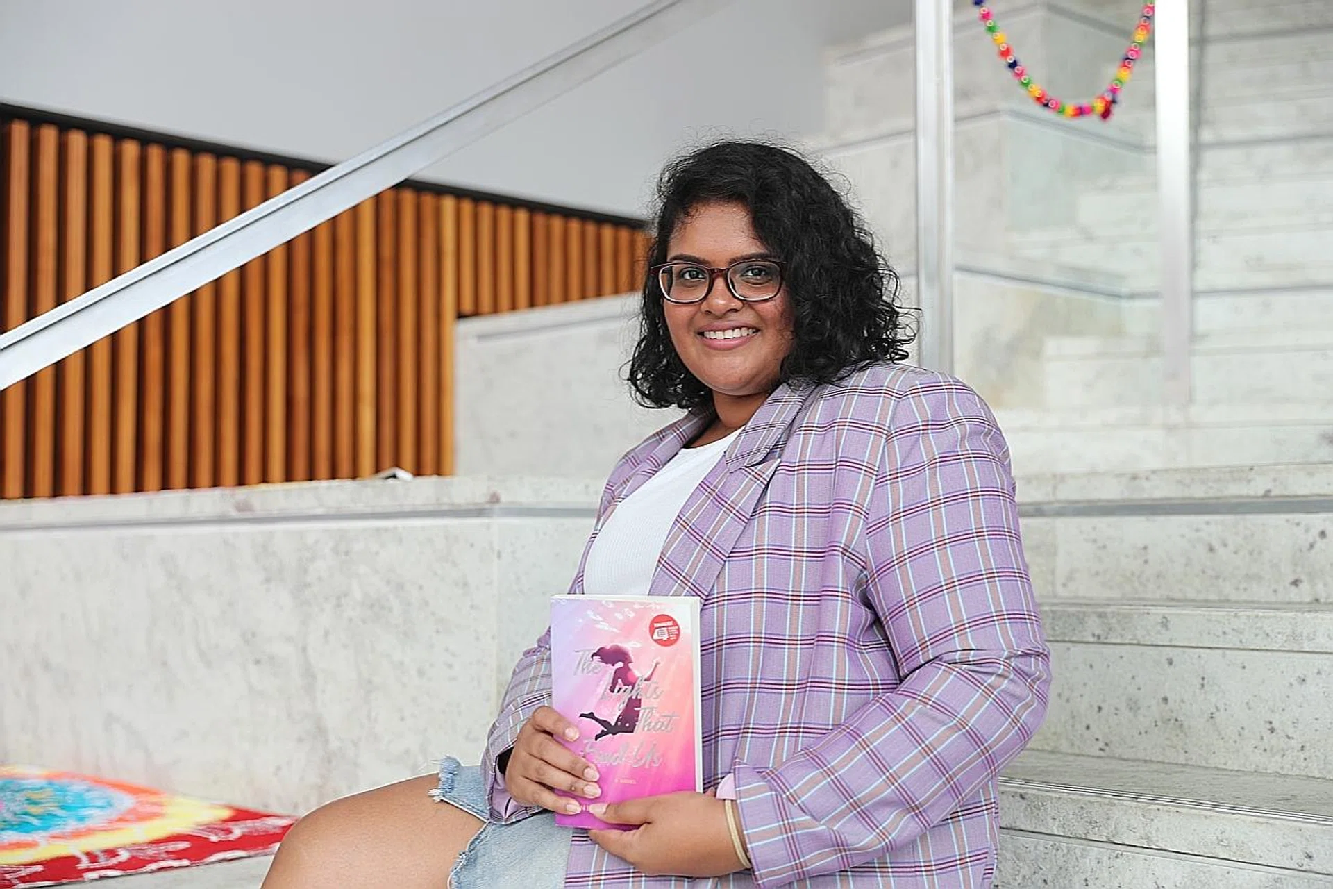 Anittha Thanabalan with her book, The Lights That Find Us. She hopes "readers would see that there are very few mistakes that are truly insurmountable".  