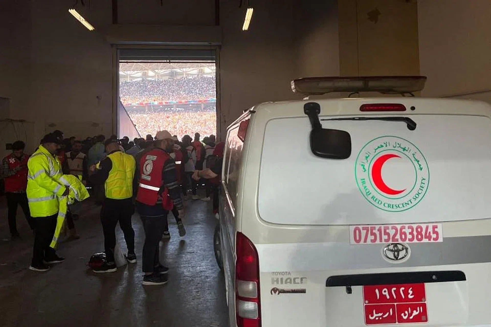An ambulance transports injured football spectators into an emergency area at the Basra International Stadium. 
