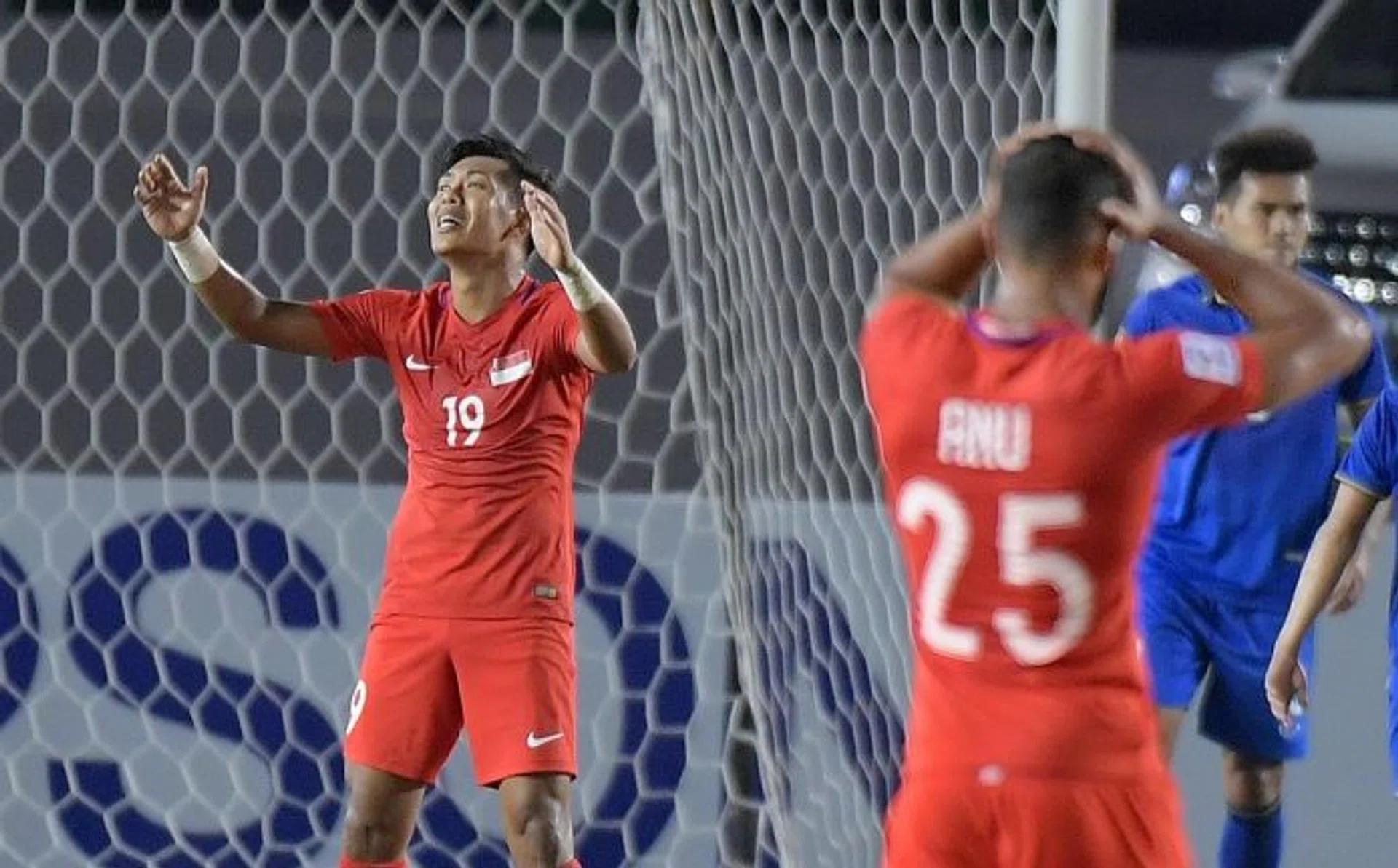 MISSING THE EDGE: Singapore striker Khairul Amri (above) lamenting a missed chance but it was Thailand's Sarawut Masuk ( on the ground) who didn't miss for Thailand.  