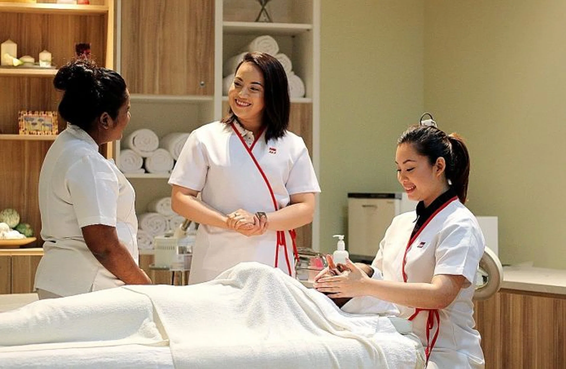 TEACHING: Ms Shuner Villanueva Leong (centre) and Ms Chua Ka Wen, who is demonstrating how a lesson in facial is carried out.