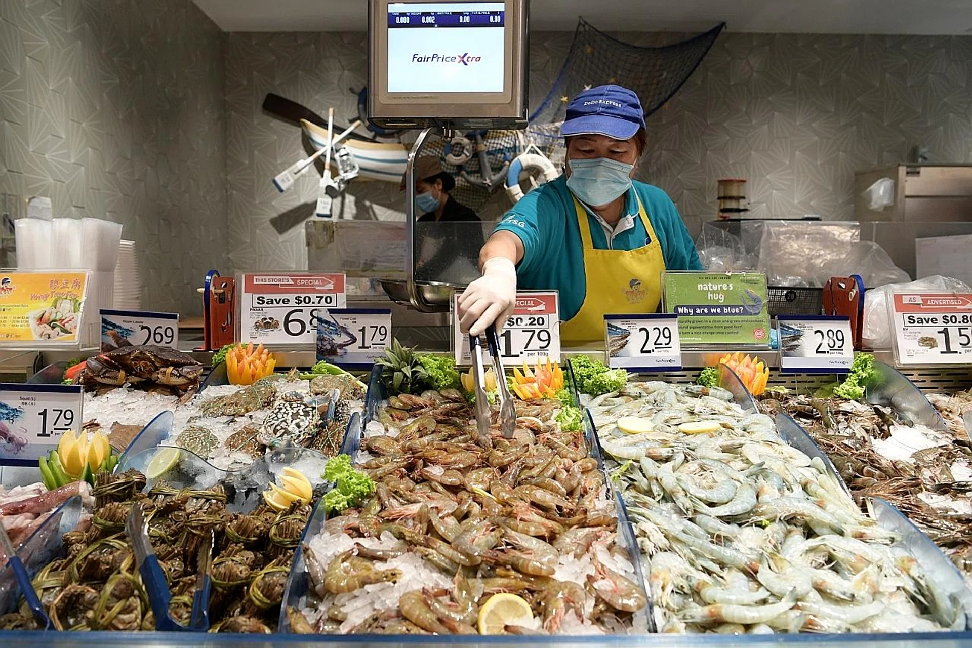 A FairPrice employee arranging Red Sea shrimps at the branch in VivoCity. Around 60 tonnes of shrimps have been imported so far, with another 60 tonnes expected to be here by the end of the year.