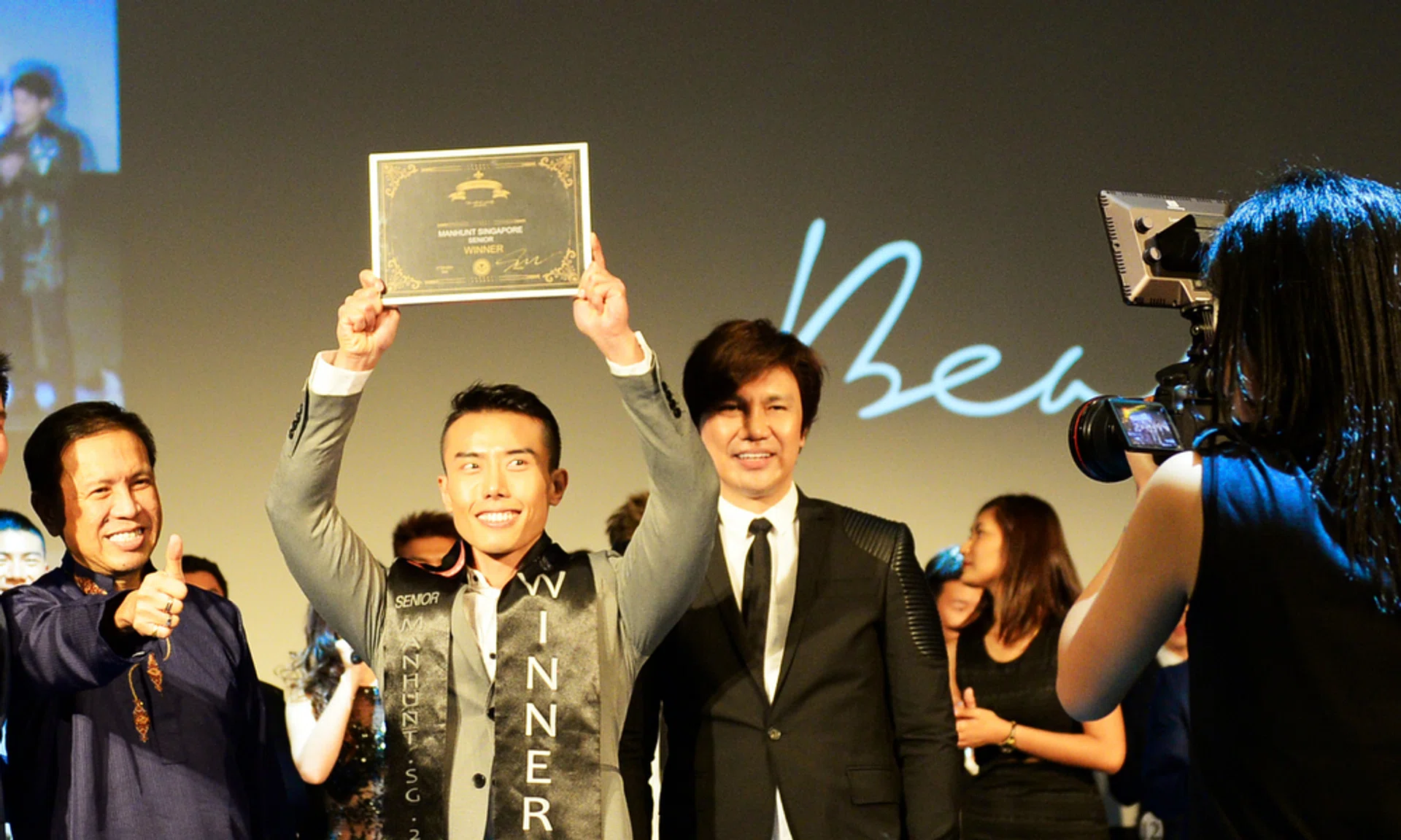 Manhunt Senior winner Mr Stanley Nam (centre) made a beeline for his mother when he was announced as the winner. 