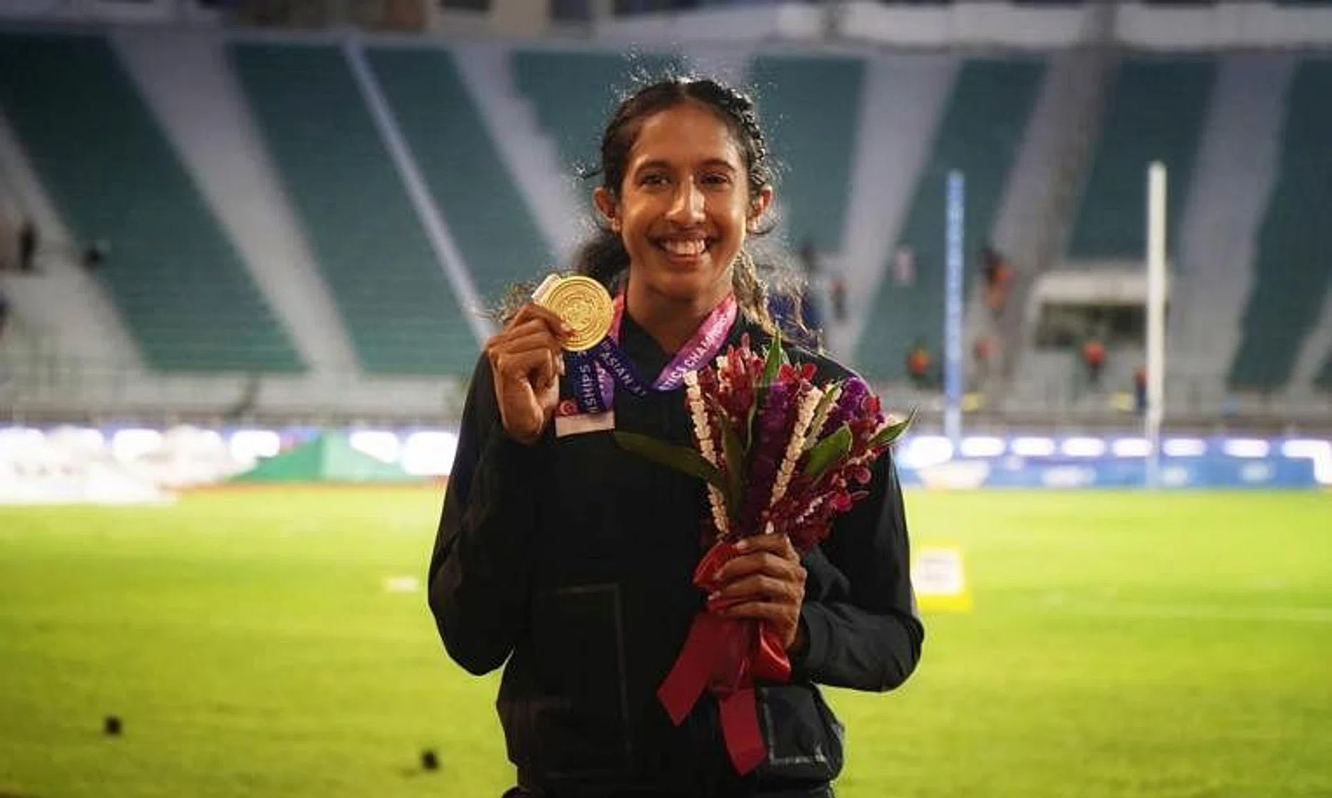 Shanti Pereira proudly shows her 200m gold after the presentation ceremony.