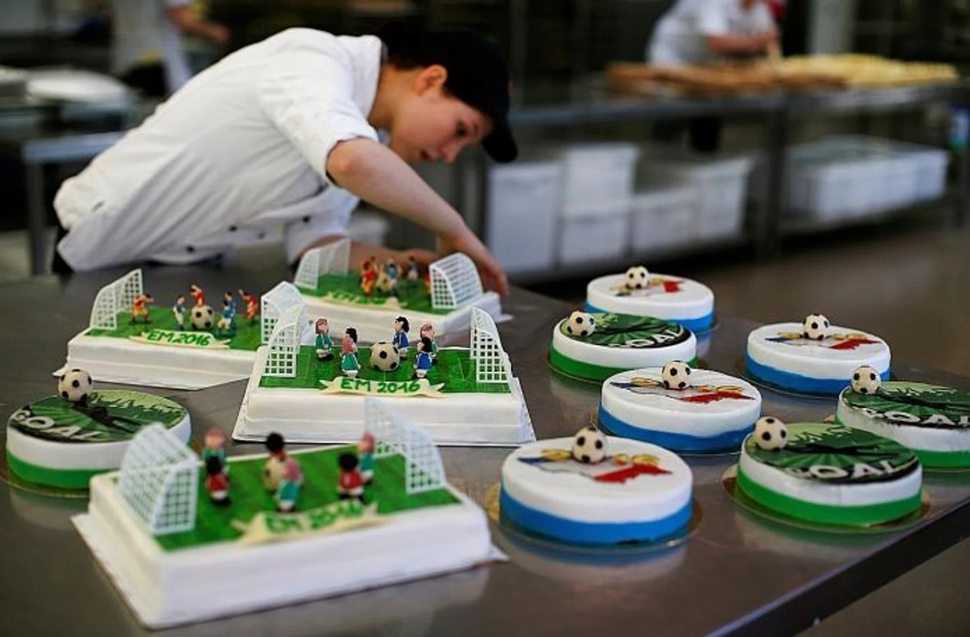 ADDING ICING: A confectioner preparing Euro 2016-themed cakes in Munich.