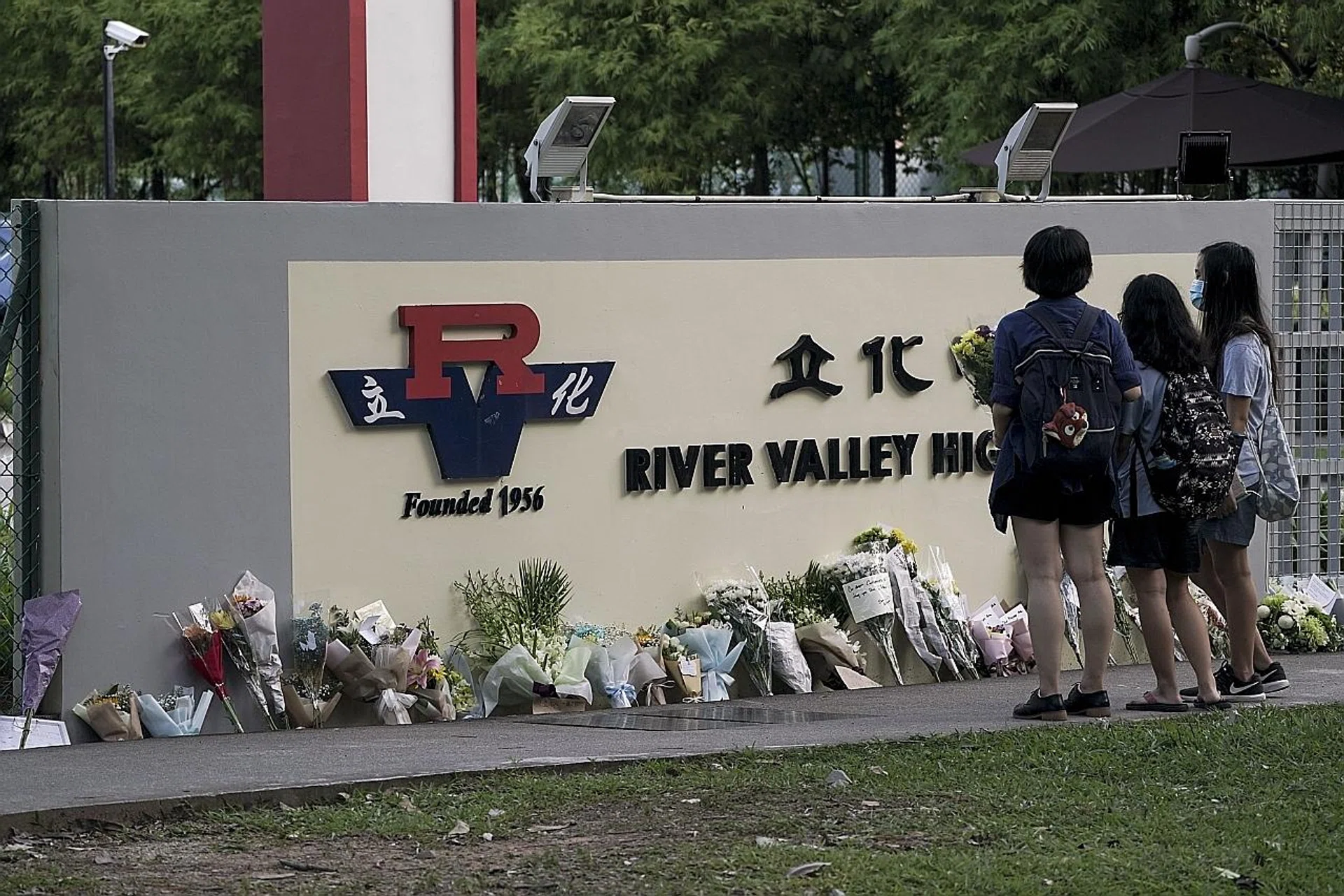Flowers placed at a wall near the main gate of River Valley High School in memory of the Sec 1 boy who was allegedly killed by a Sec 4 student in school on Monday. 