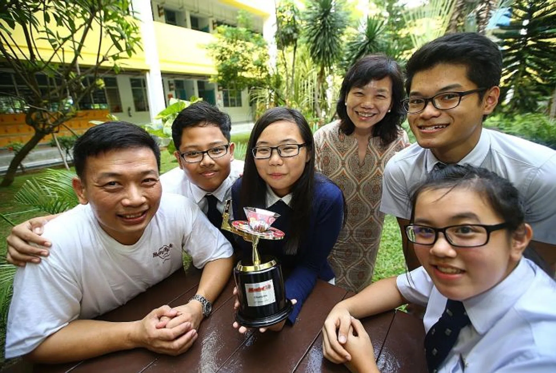  WINNERS: (From left) Beatty Secondary School teacher Alexander Choy, Muhd Zulfazlin Zainal, Chua Hui Min, school principal Marion Tan, Evan Tan Jia Ho and Ang Jia Shing Adeline with their N.E.mation!10 champion trophy.