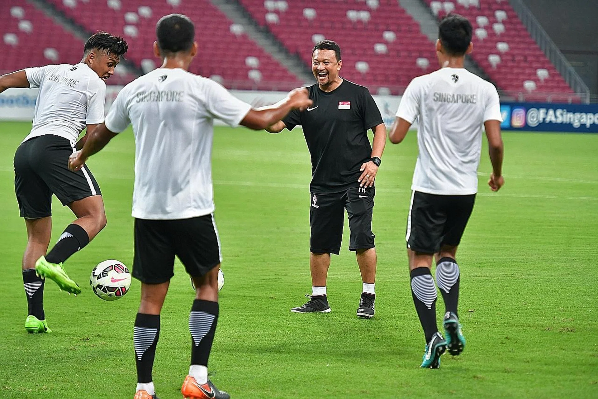 Coach Fandi Ahmad (in black) says his team will enter tonight's game against their Indonesian Under-23 counterparts with a winning mindset. 