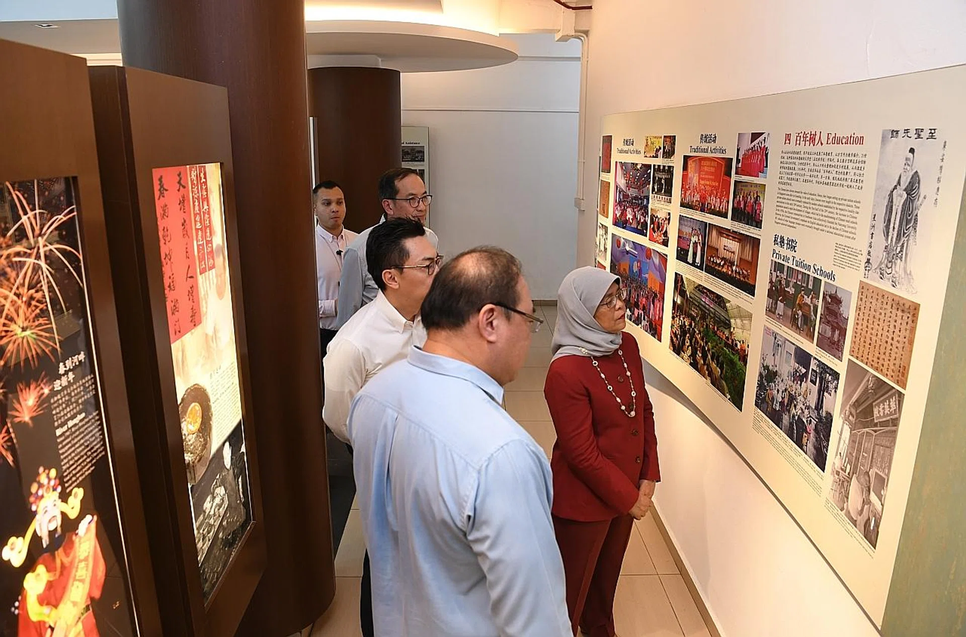 President Halimah Yacob viewing the Singapore Federation of Chinese Clan Associations heritage gallery with SFCCA president, Mr Tan Aik Hock (in blue). 
