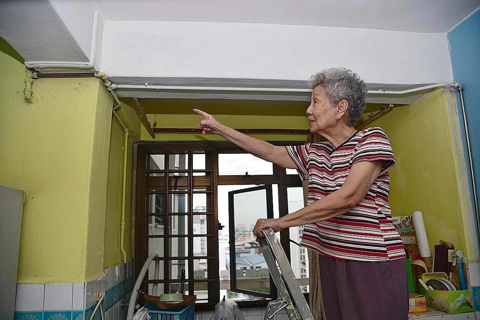 Madam Gan Leng Neo pointing to the work that was done on her ceiling. 