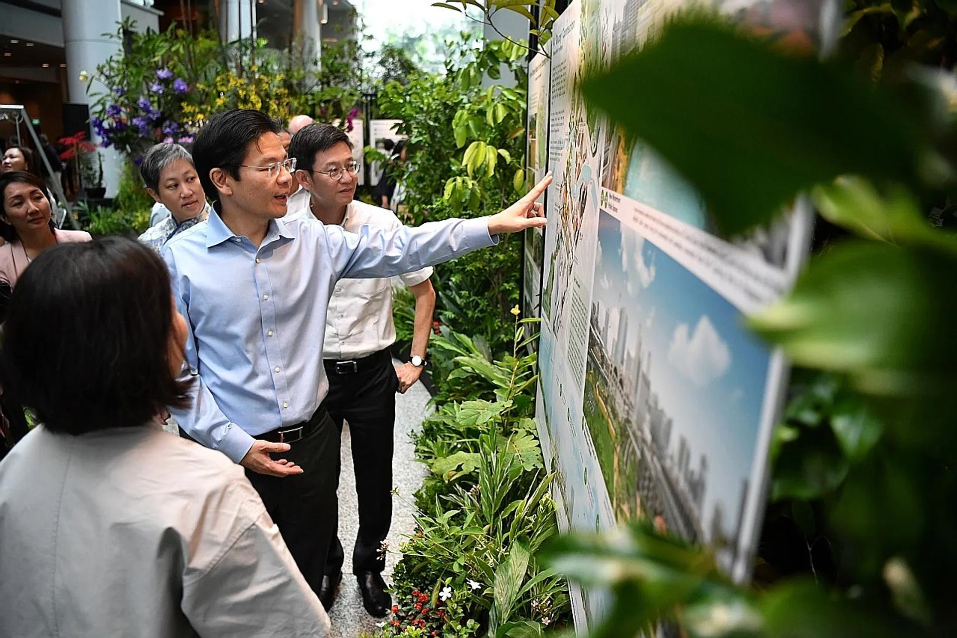National Development Minister Lawrence Wong accompanied by URA CEO Lim Eng Hwee, (to his left) touring the "A Green Oasis in the City: From Orchard to Singapore River" exhibition at the URA Centre yesterday. 