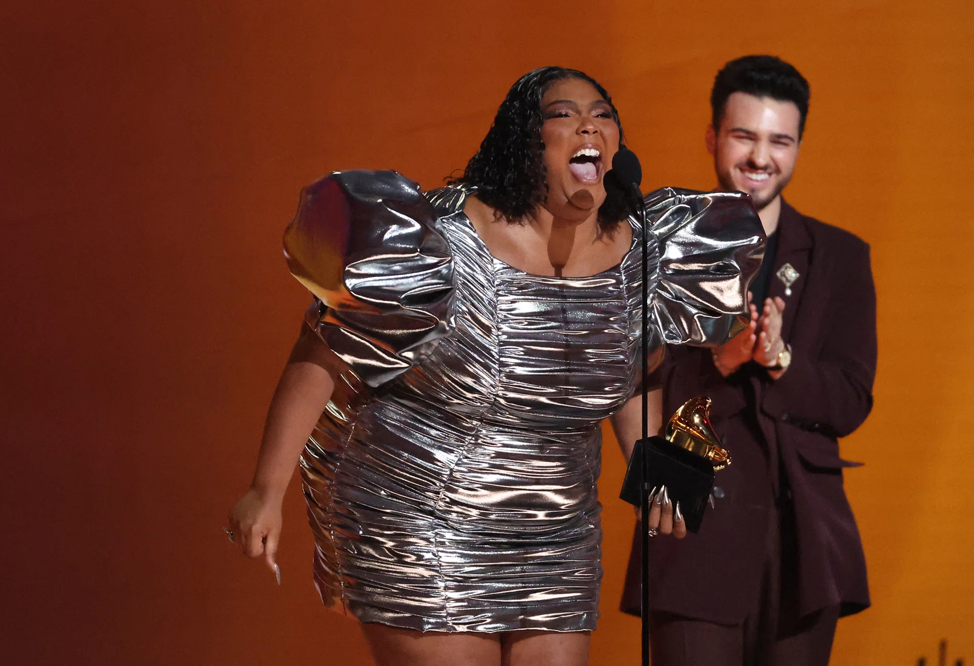 Lizzo (left) accepts the Record Of The Year award for About Damn Time.