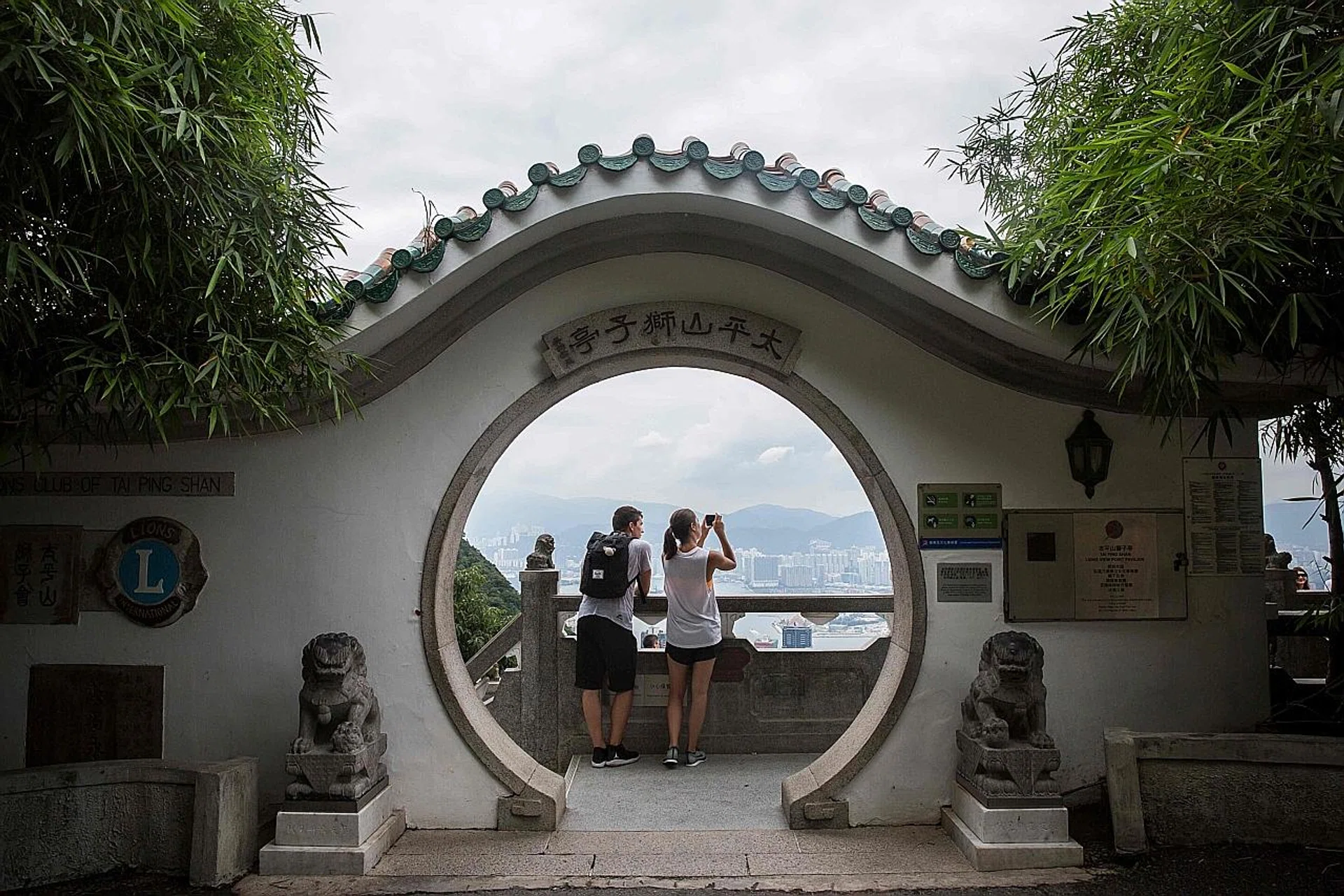 Tourists taking in the sights of Hong Kong from the peak (above) and the Roman Agora archaeological site in Athens. 
