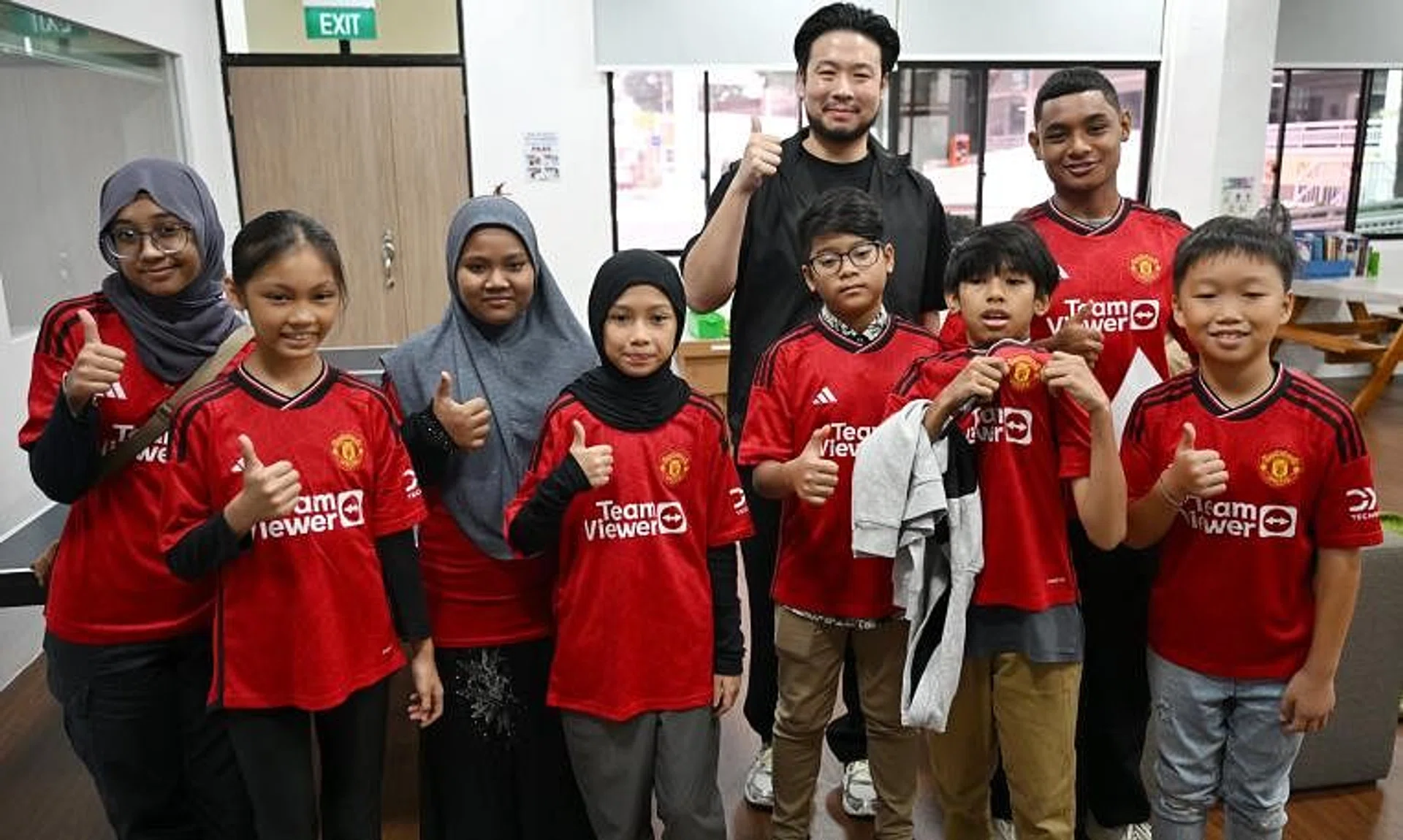Mr Kiat Lim (in black) with the eight children and youth going to Manchester.
