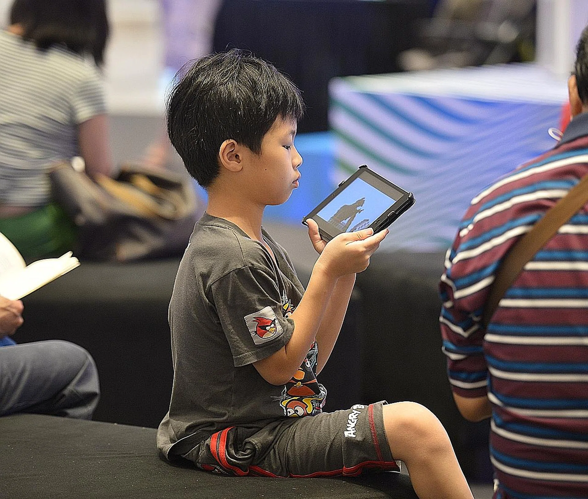 A boy engrossed in an iPad.