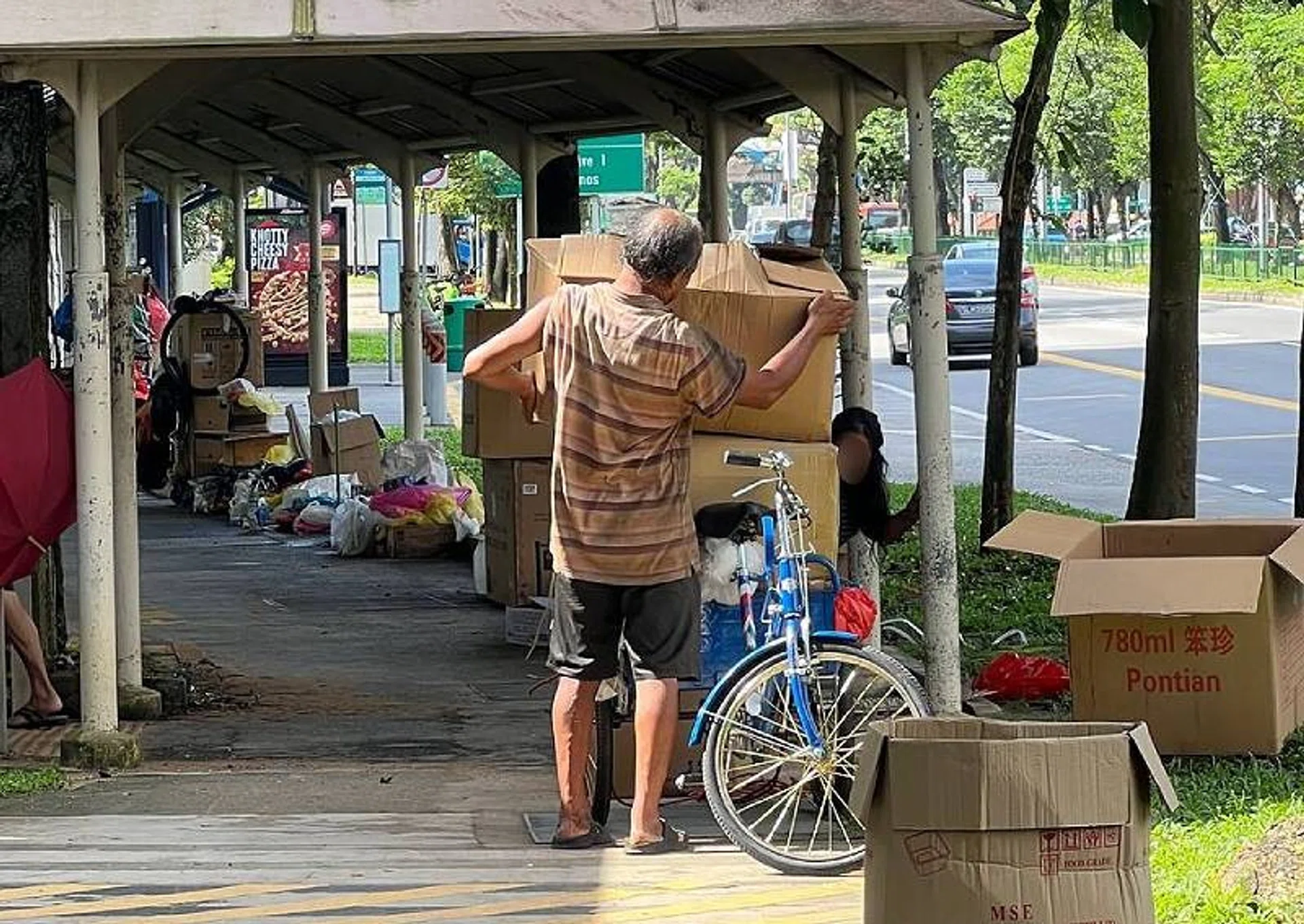 Wang and his wife loading cardboard boxes onto a bicycle.

