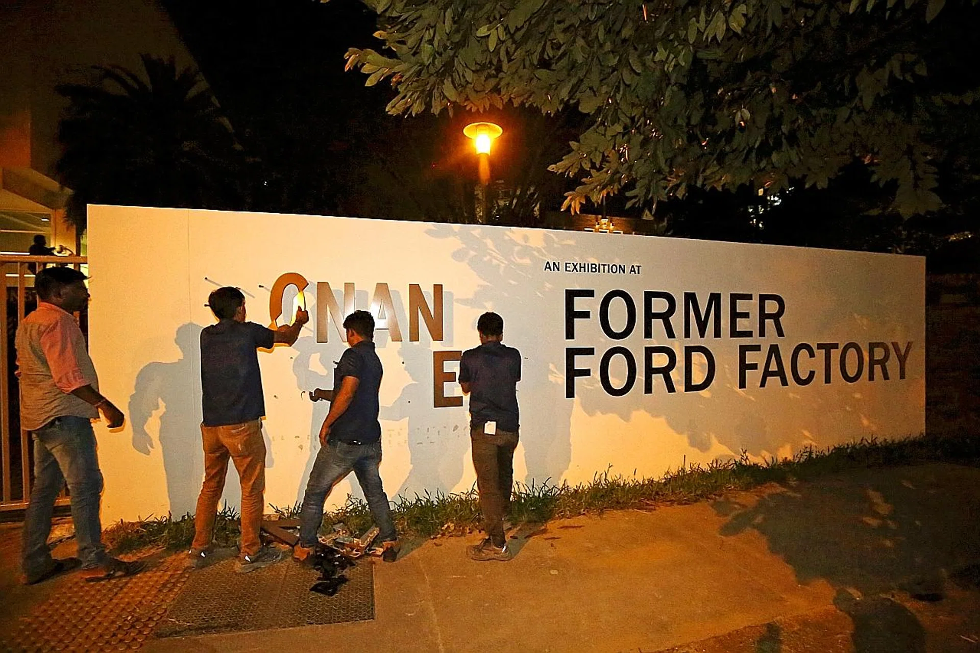 Workers removing the Syonan Gallery signage at the Former Ford Factory last night. PHOTO: LIANHE ZAOBAO