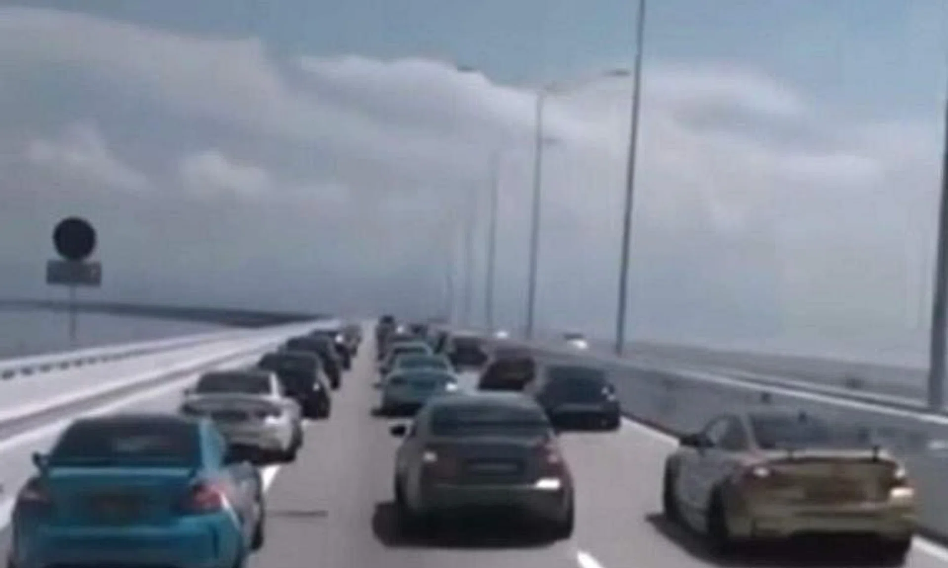 Rows of BMW cars were driving along all three lanes of the bridge, including the emergency lane on the left. 