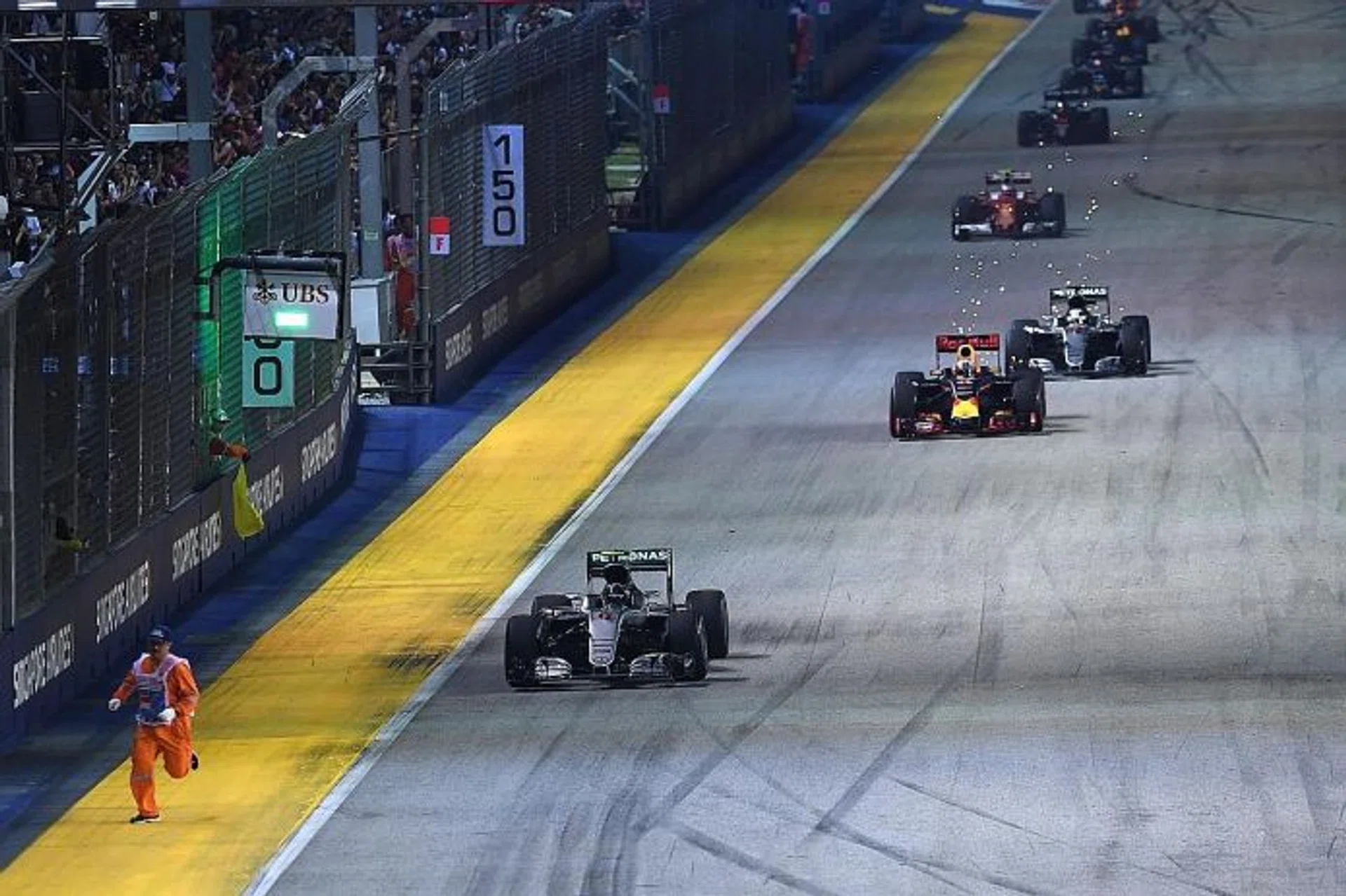 CLOSE SHAVE: A marshal (left, in orange) is seen rushing off the track during the third lap, as Mercedes' Nico Rosberg leads the trail of speeding F1 cars back into the race.
