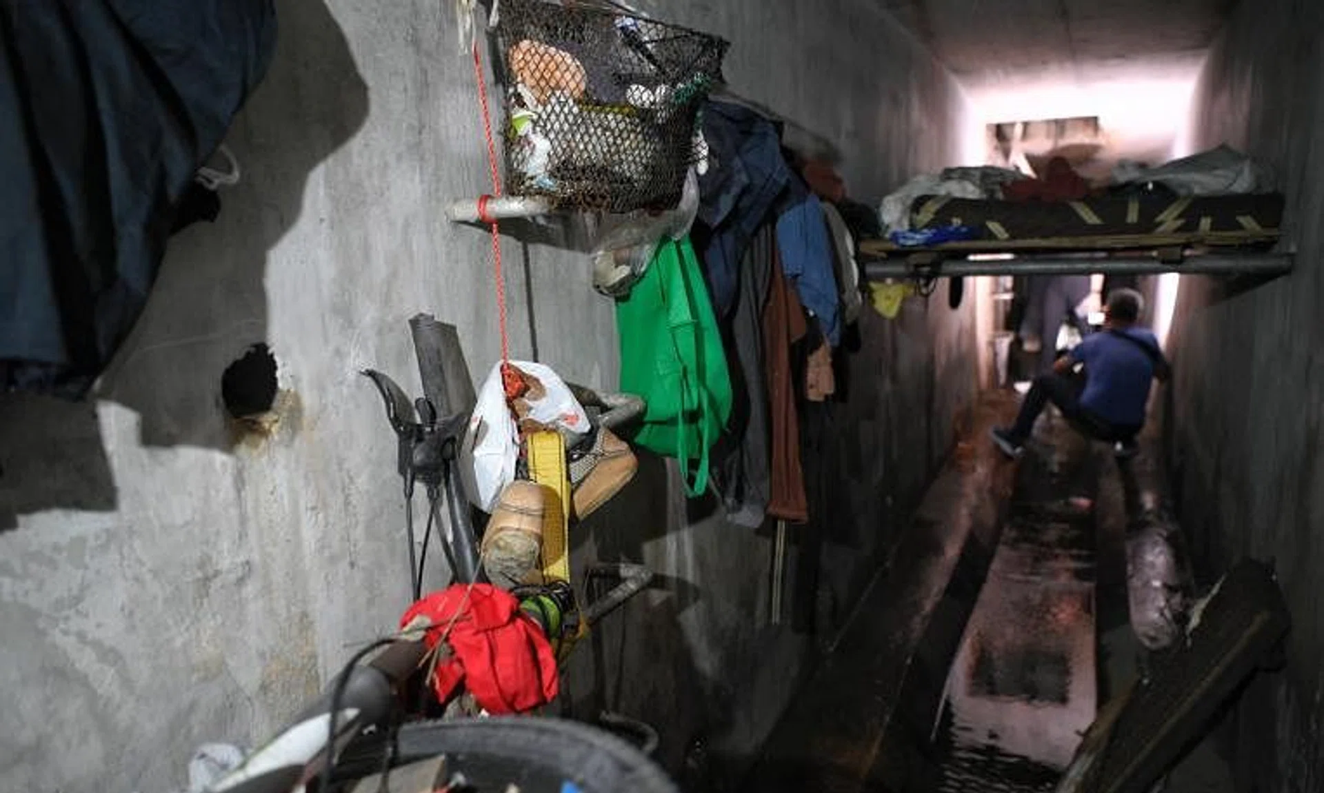 Clothes, a makeshift bed and other items are seen inside a drain around the Sungei Kadut Industrial Estate area during a raid by the police on Dec 5.