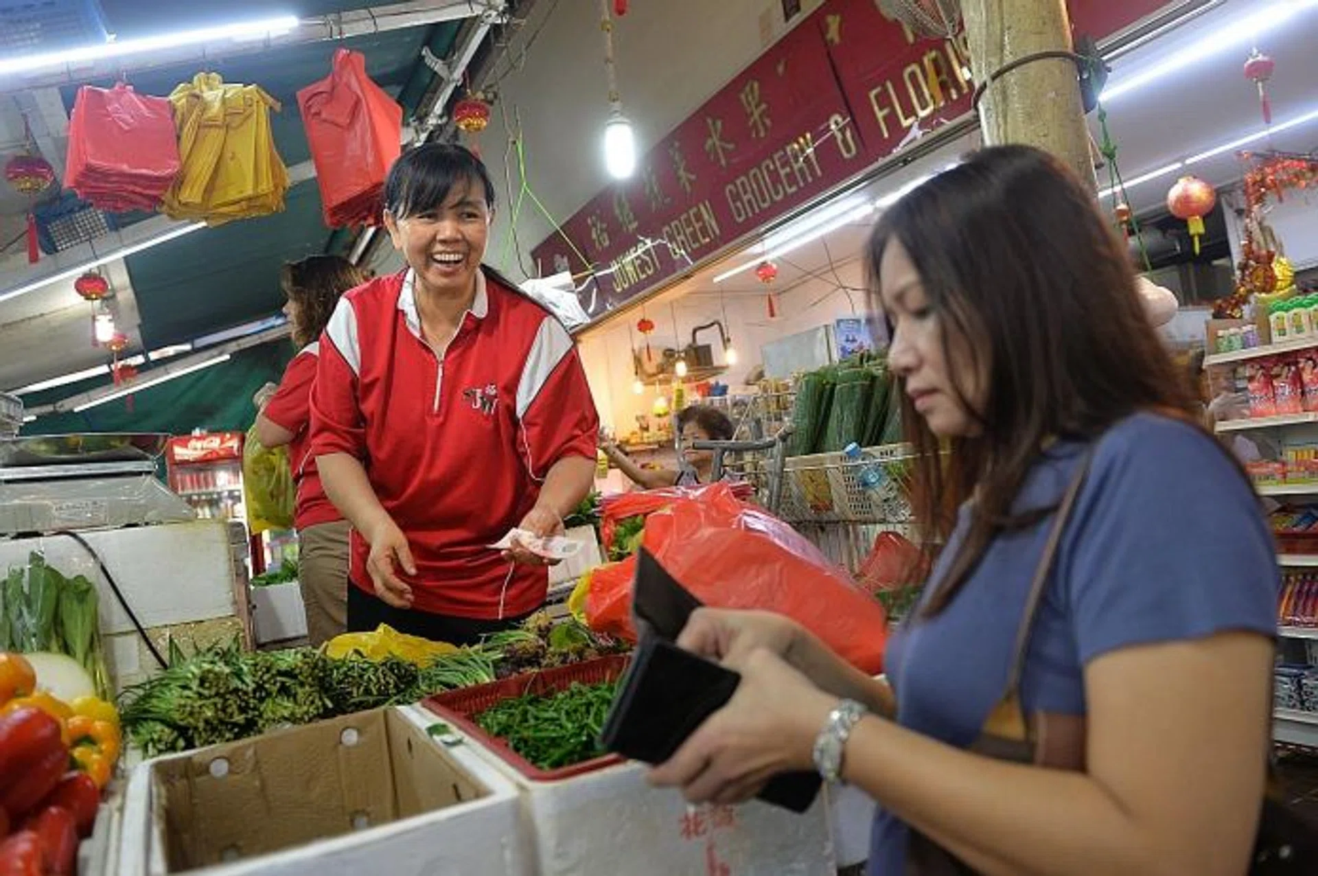 FAMOUS: Everyone at Jurong West knows vegetable seller Beh Poh Gek (in red shirt) for her friendliness and loud voice.
