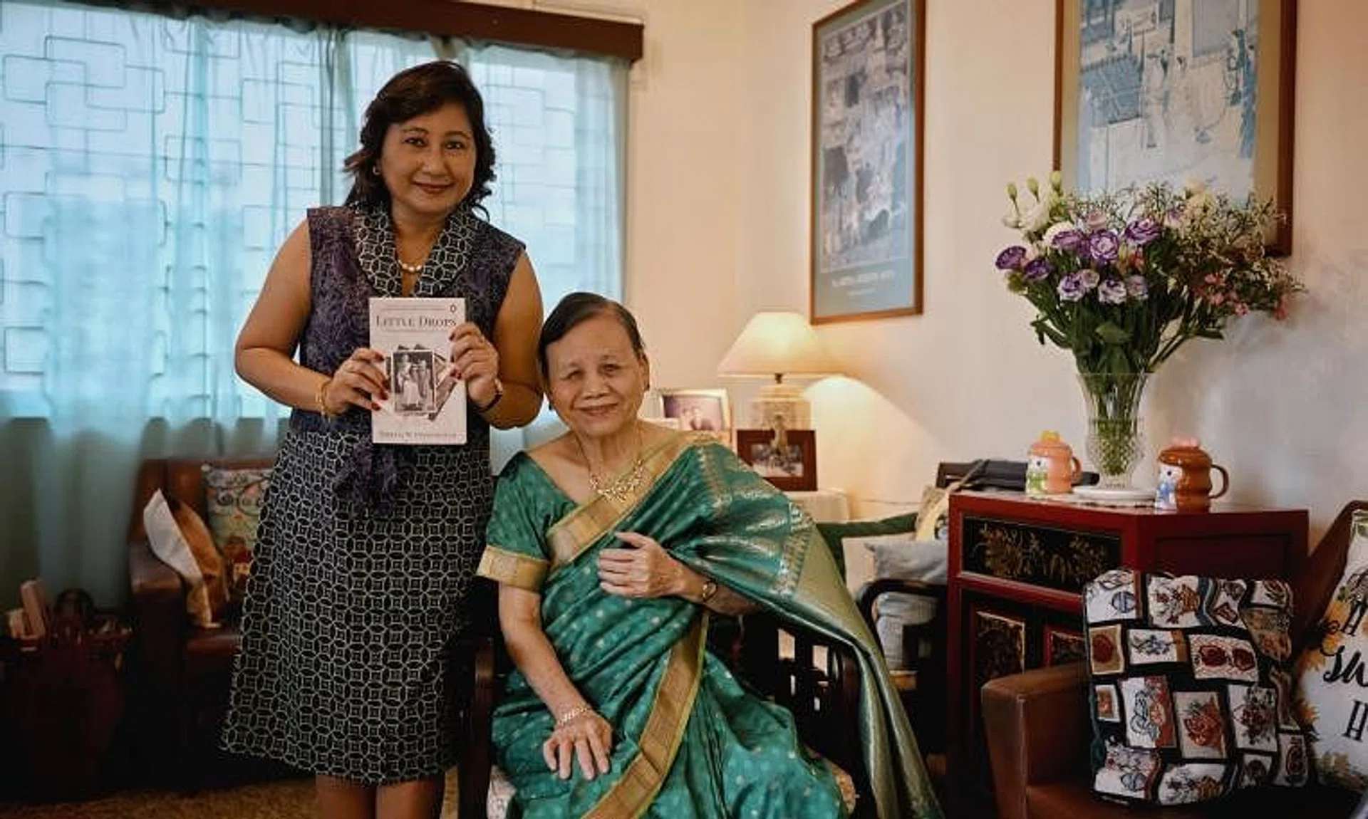 Social scientist Theresa Devasahayam posing with her book and her mother, Mrs Jane Devasahayam, who was adopted.