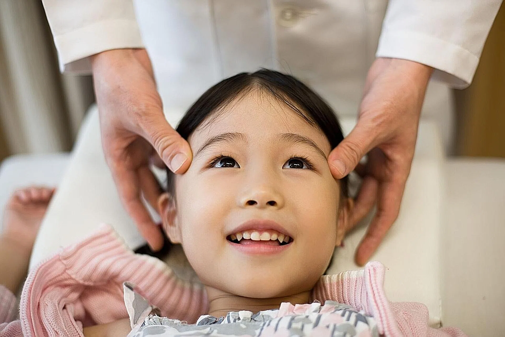A physician performing pediatric tuina on a child. 