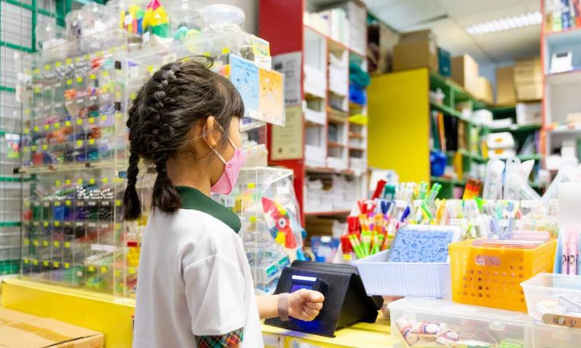 A pupil making a purchase at a POSB Smart Buddy tap-and-pay terminal at Xishan Primary School's bookstore.