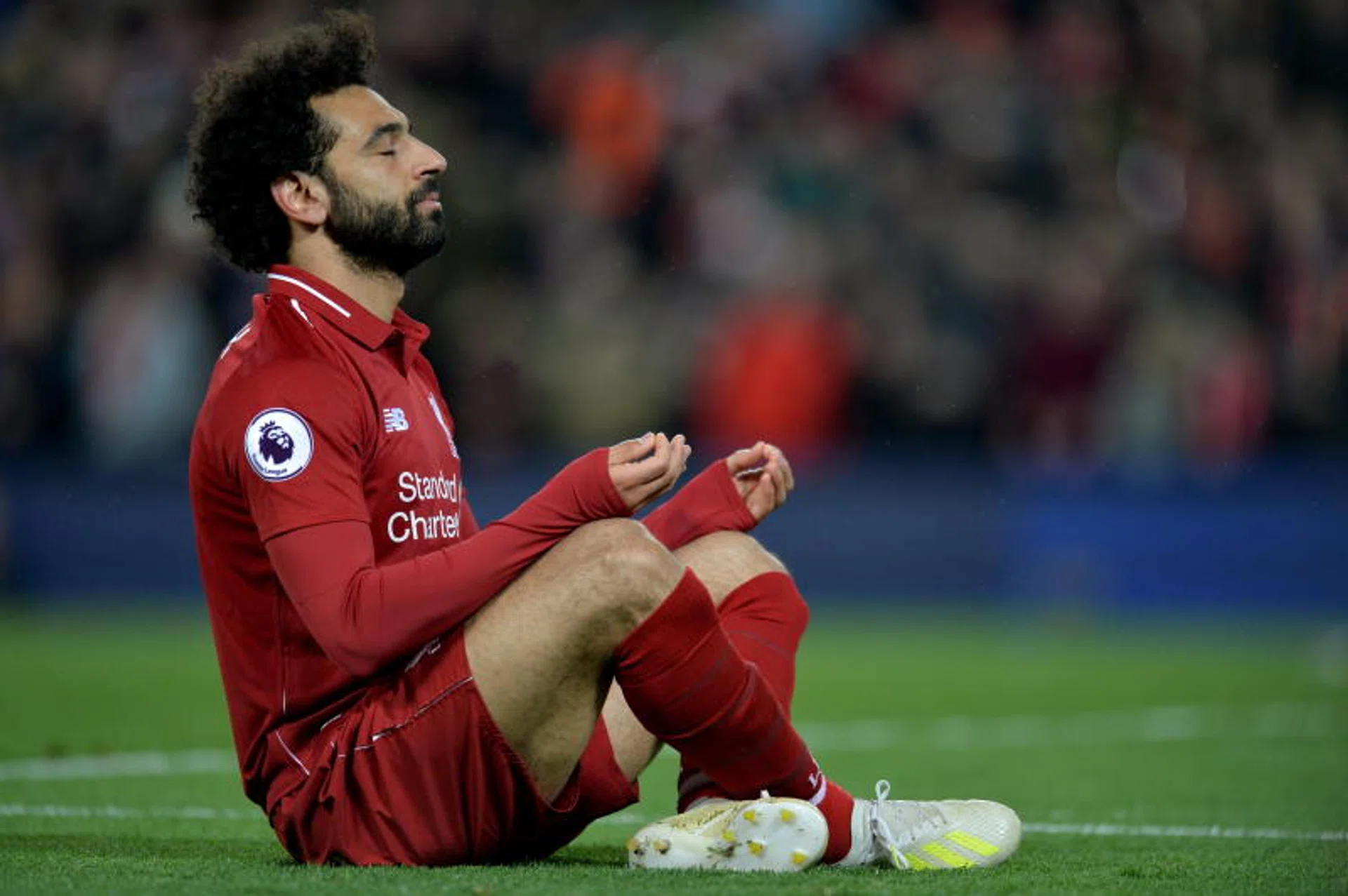 Mohamed Salah celebrates with a meditation pose after scoring against Huddersfield.