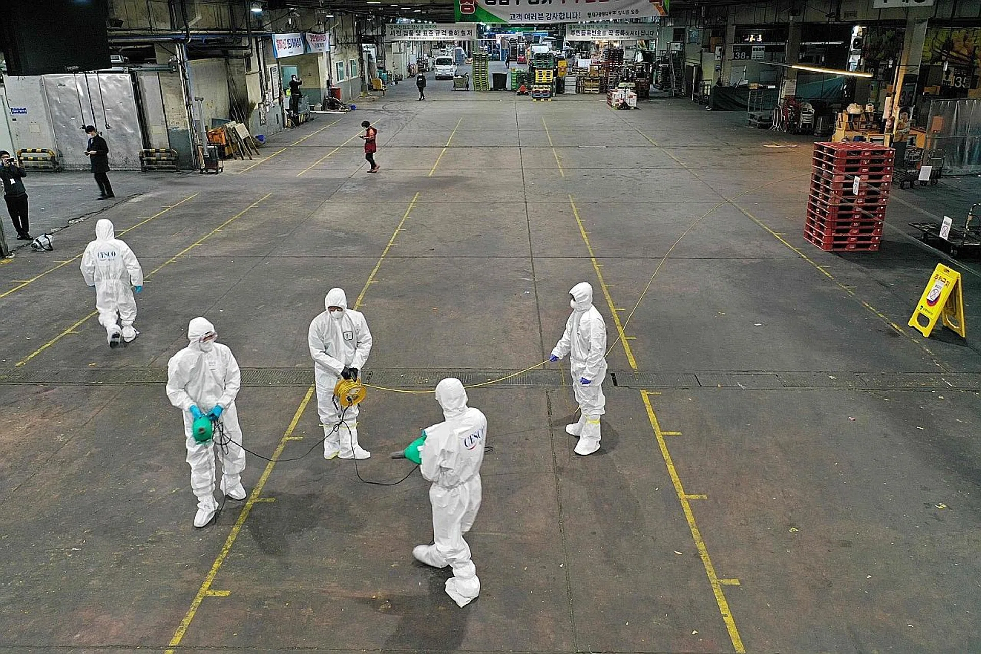 Workers spraying disinfectant at a market in Daegu . 