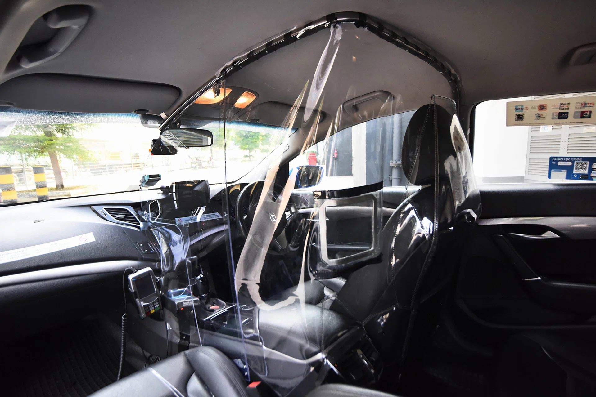 The shield encases the driver's area, and has two openings for passengers to make payment. 
