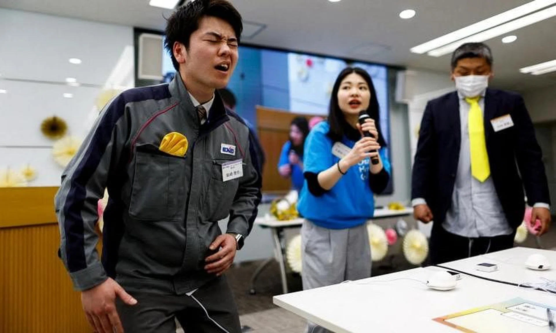 A male employee of Exeo Group wincing as he tries out the “perionoid”, a device which simulates menstrual pain.