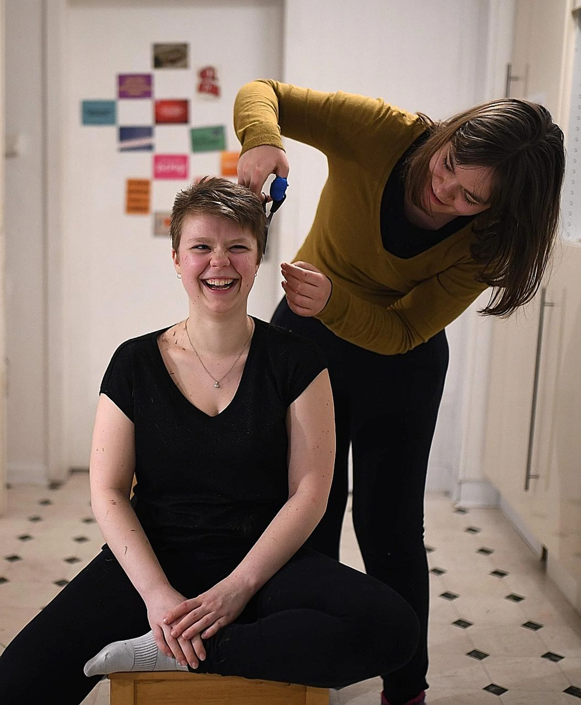 (Above) A woman in Germany cuts her flatmate's hair. 