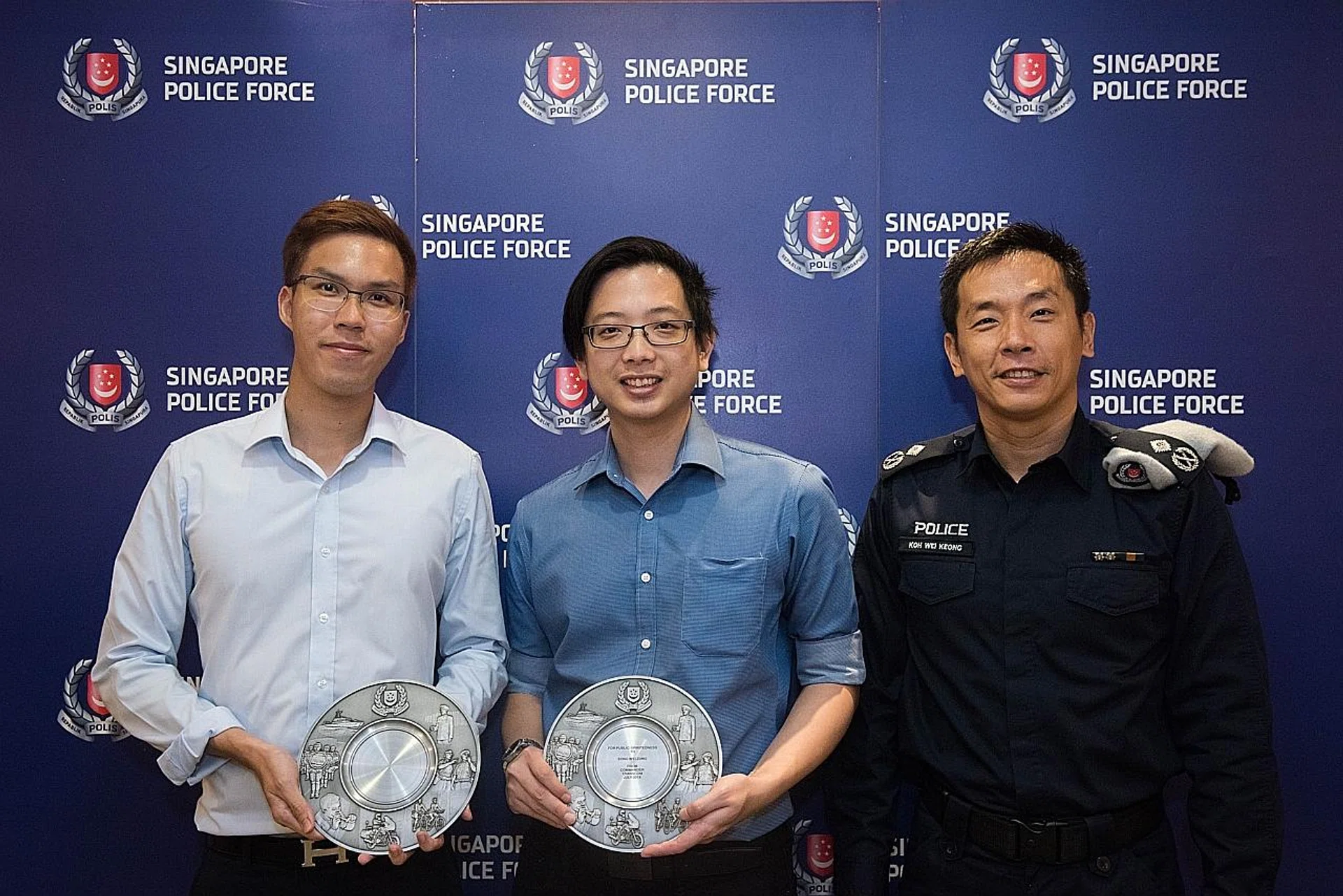 (From left) Mr Justin Law Jieting and Mr Song Wei Zong receiving their awards from Assistant Commissioner of Police Koh Wei Keong. 