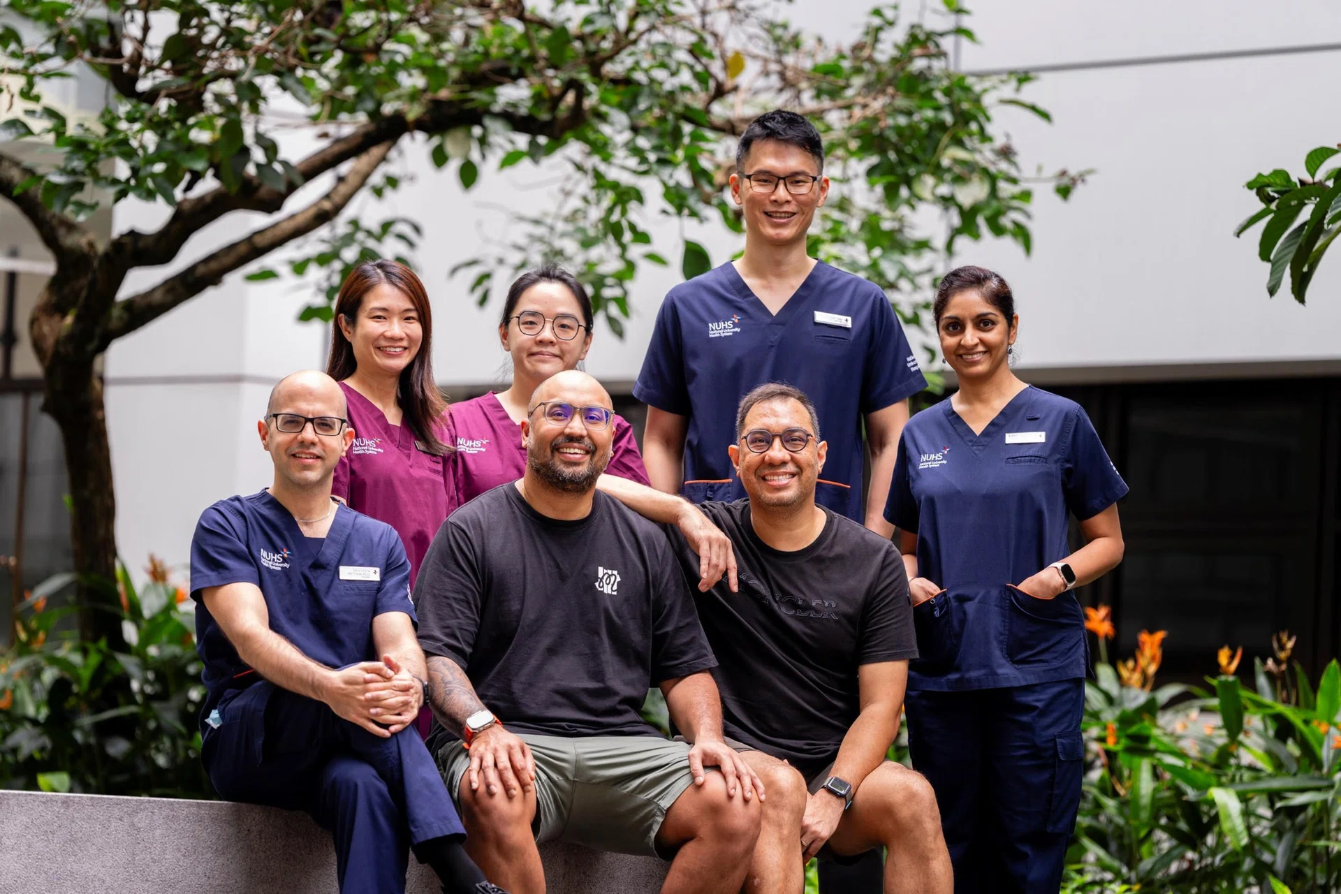 Mr Marc de Vries (seated, second from right) with his brother Carl (seated, right) and their medical team from NUH.
