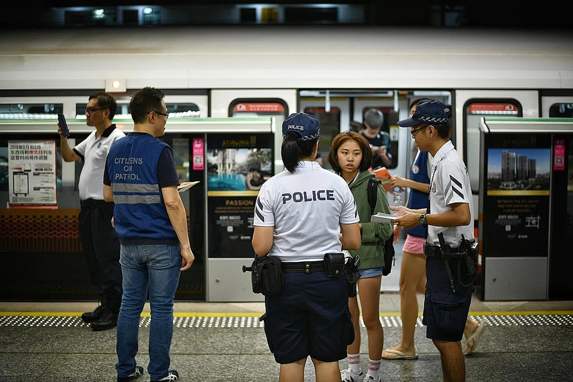 Volunteers handing out fliers at Queenstown MRT station during the pilot run on Aug 13.