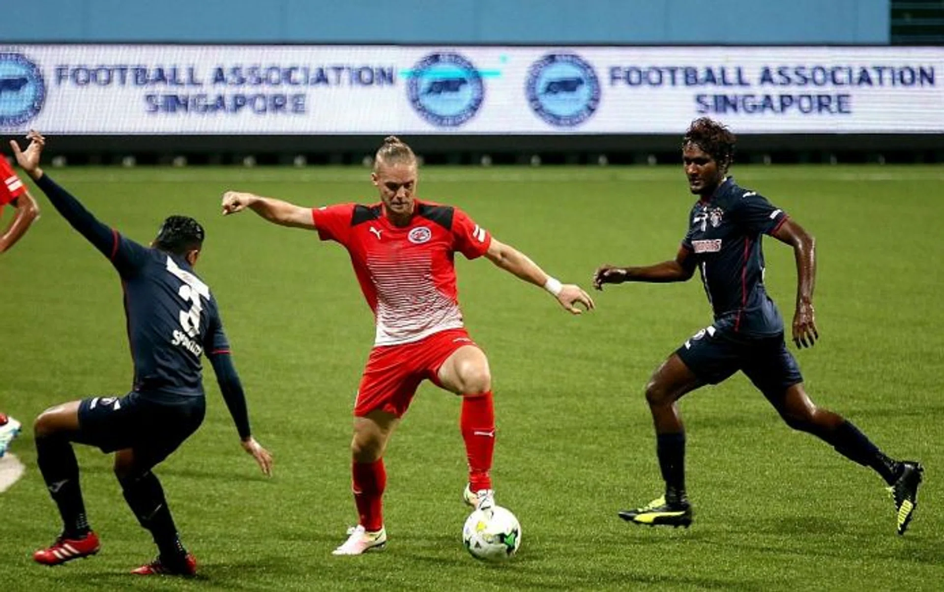 TWO TO TANGO: Home United's Ken Ilso (in red) controlling proceedings as Warriors FC's Syaqir Sulaiman keeps a close watch.