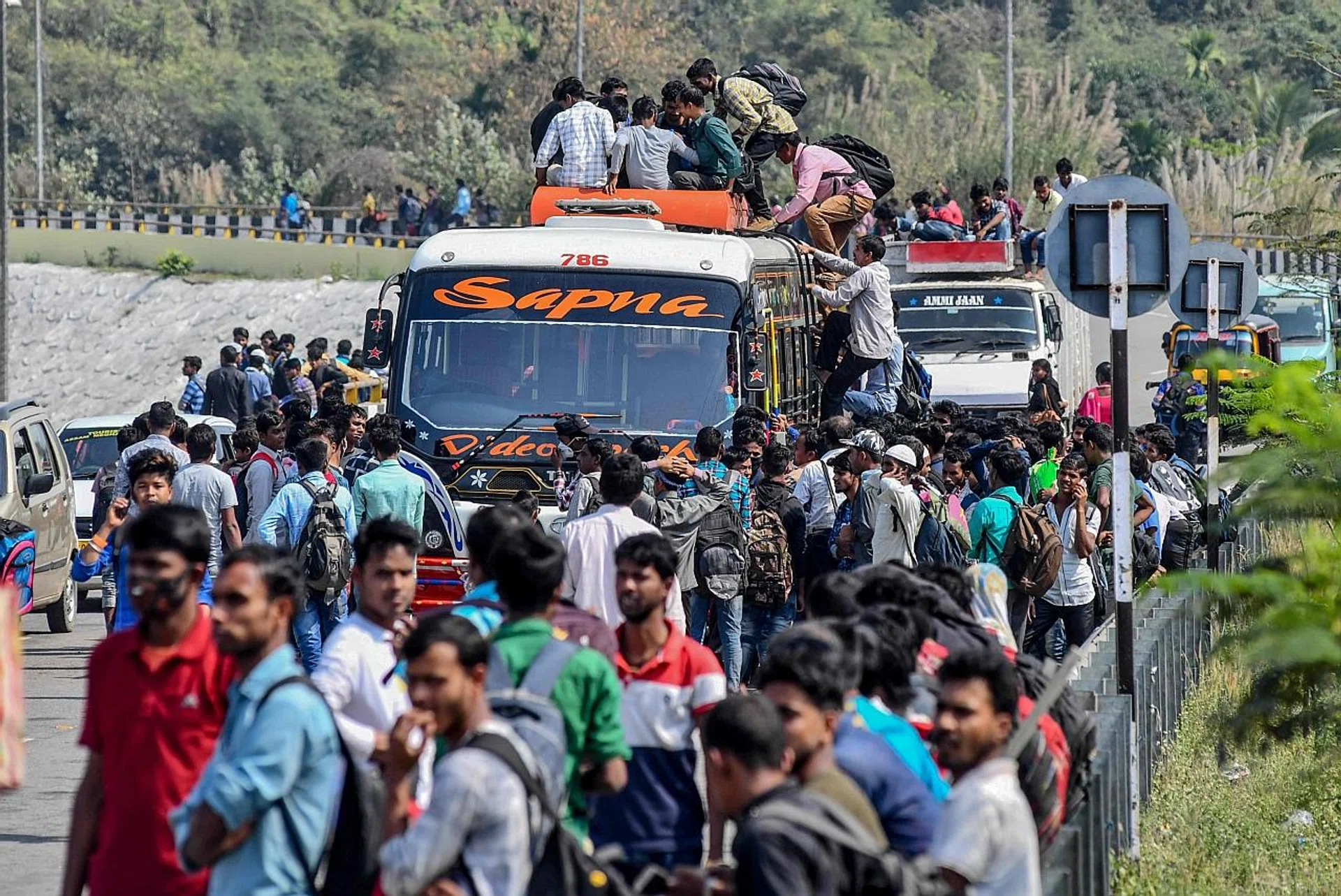 People on the roof of a crowded bus to get home ahead of a government-imposed lockdown as a preventive measure against the coronavirus in Guwahati, Assam. 