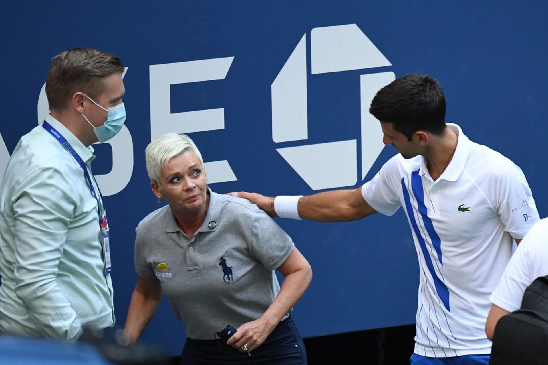 Novak Djokovic (right) checking if the line judge is hurt after a ball he hit away in frustration struck her on the throat. 