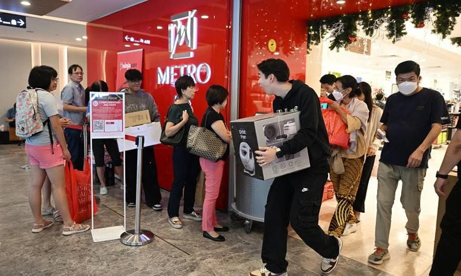 Shoppers leaving the Metro department store in Paragon to queue up for home delivery service during Black Friday on Nov 24.