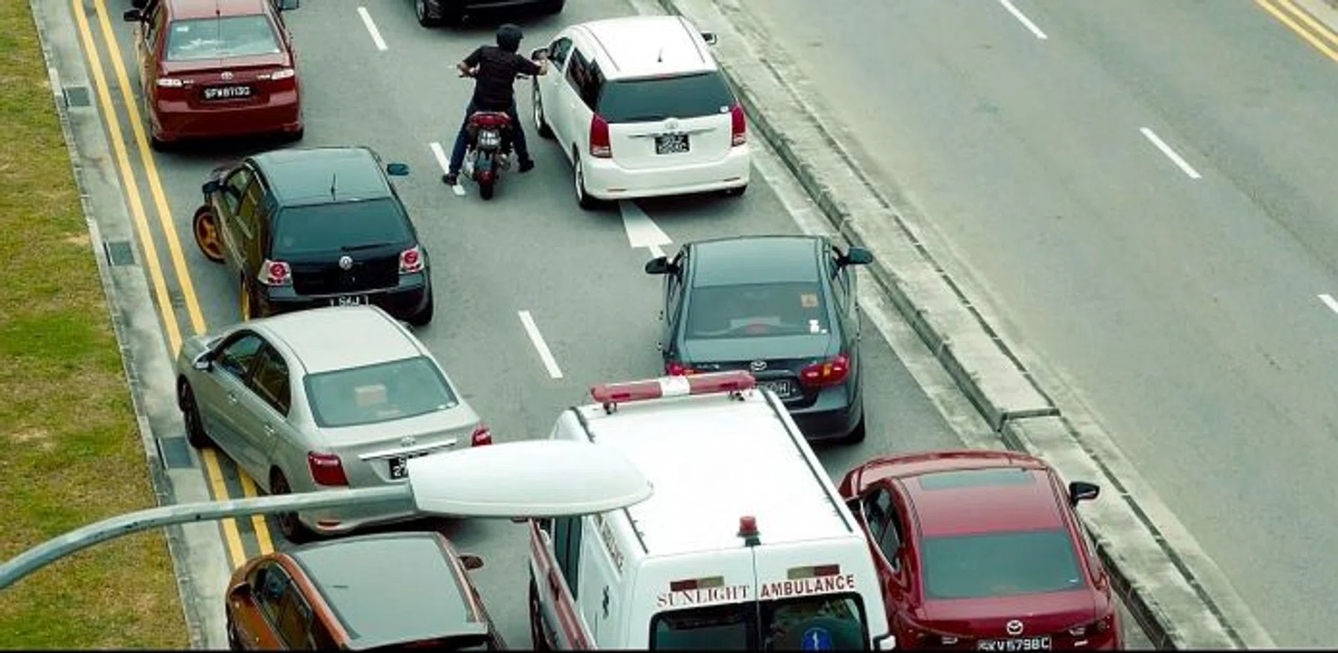 MAKE WAY: Screengrab from the People First advertisement showing Mr Mohamad Rafiq Azhar clearing the road for an ambulance. 