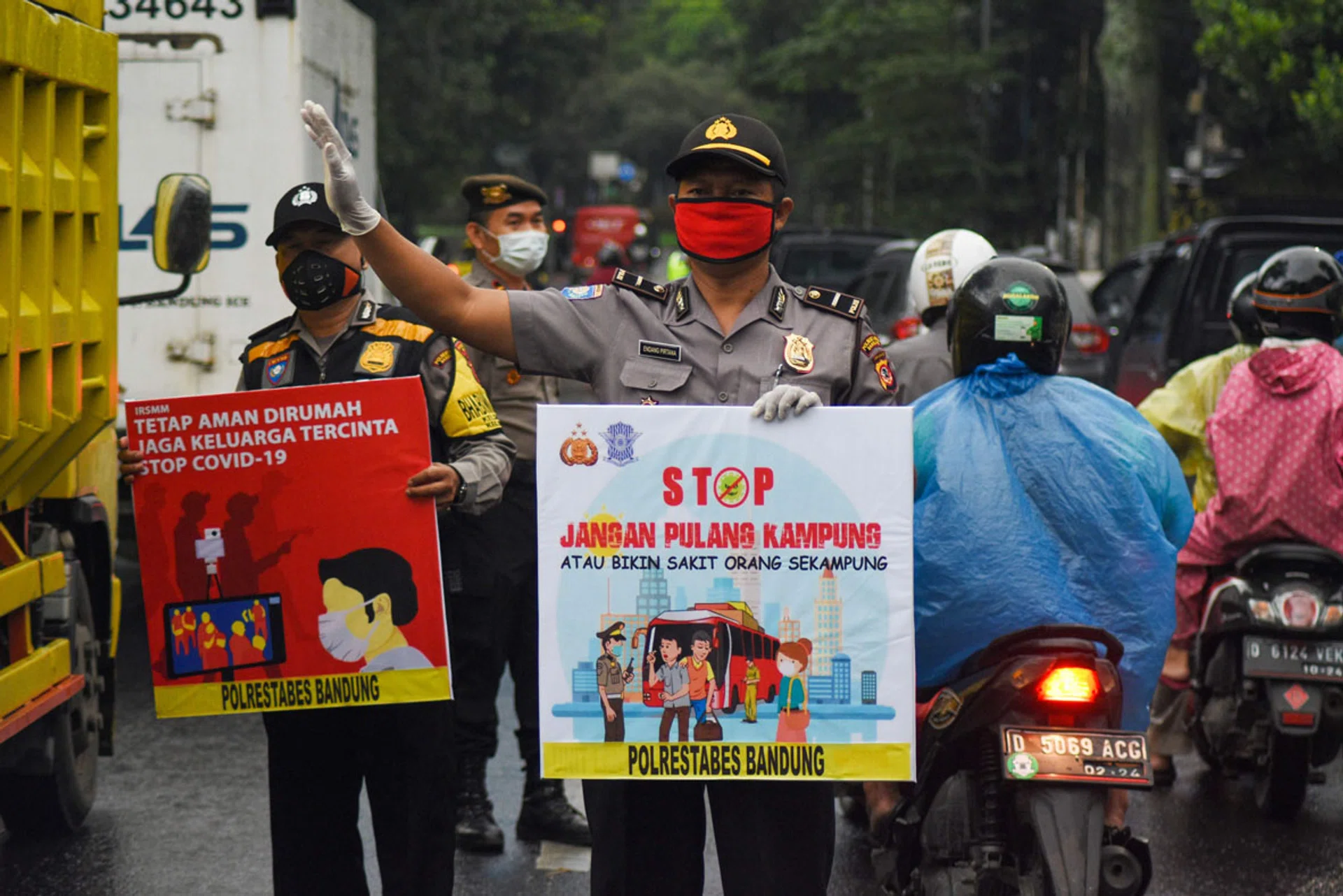 Indonesian policemen holding placards calling for members of the public to stay home amid the Covid-19 pandemic in Bandung, West Java, yesterday, a day before the implementation of large scale social restrictions by the local government. 