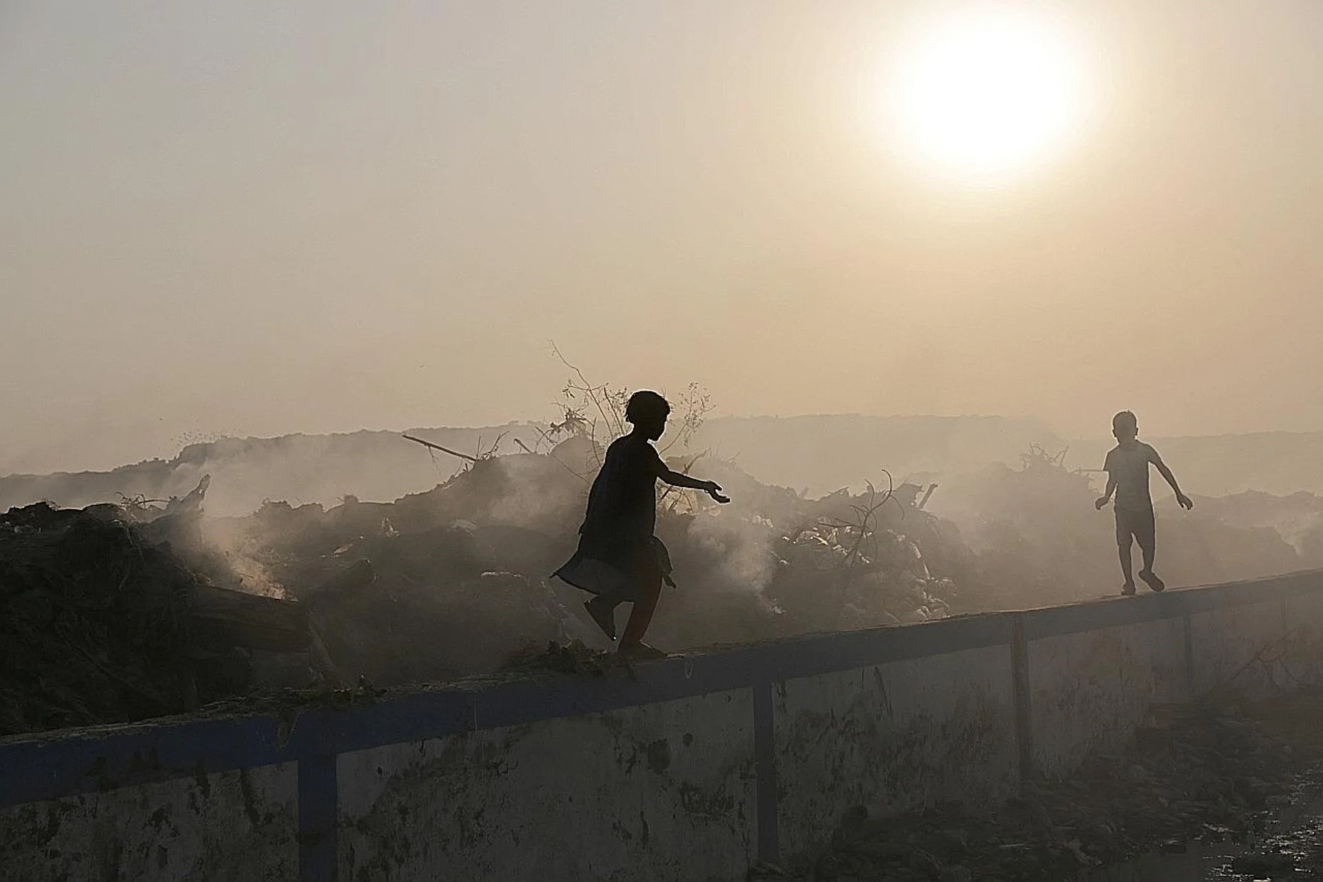 Indian children playing in an area with high levels of air pollution near a garbage dump in Calcutta. 
